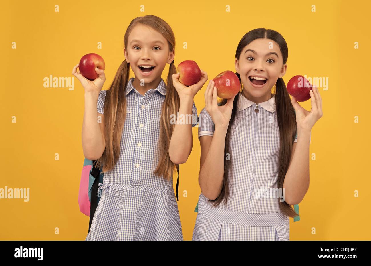Essen Sie Obst, um süß zu sein. Glückliche Schulfreunde halten Äpfel. Gesunde Ernährung. Immer richtig essen Stockfoto