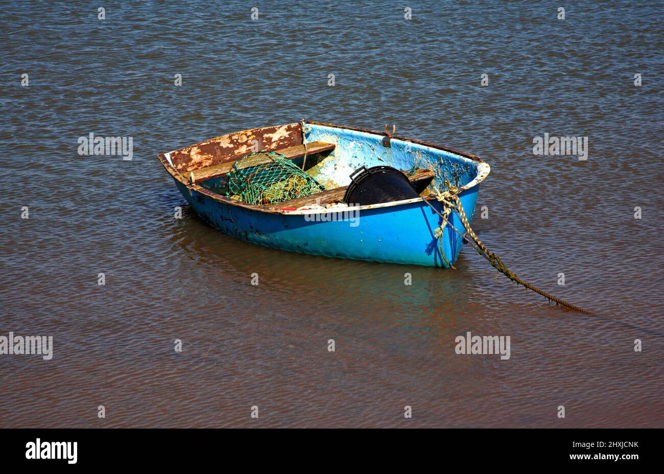 Ein kleines Boot mit Angelausrüstung vor Anker in Overy Creek an der North Norfolk Küste in Burnham Overy Staitthe, Norfolk, England, Vereinigtes Königreich. Stockfoto