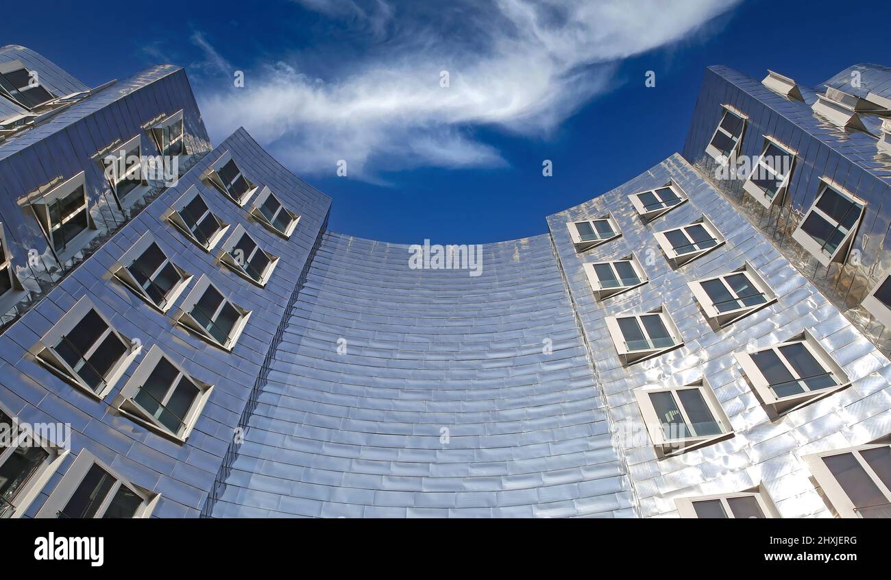 Düsseldorf (Medienhafen), Deutschland - März 9. 2022: Low-Angle-Ansicht auf Gehry Haus mit gebogenen halbrunden symmetrischen silber glänzend futuristischen metallischen A Stockfoto