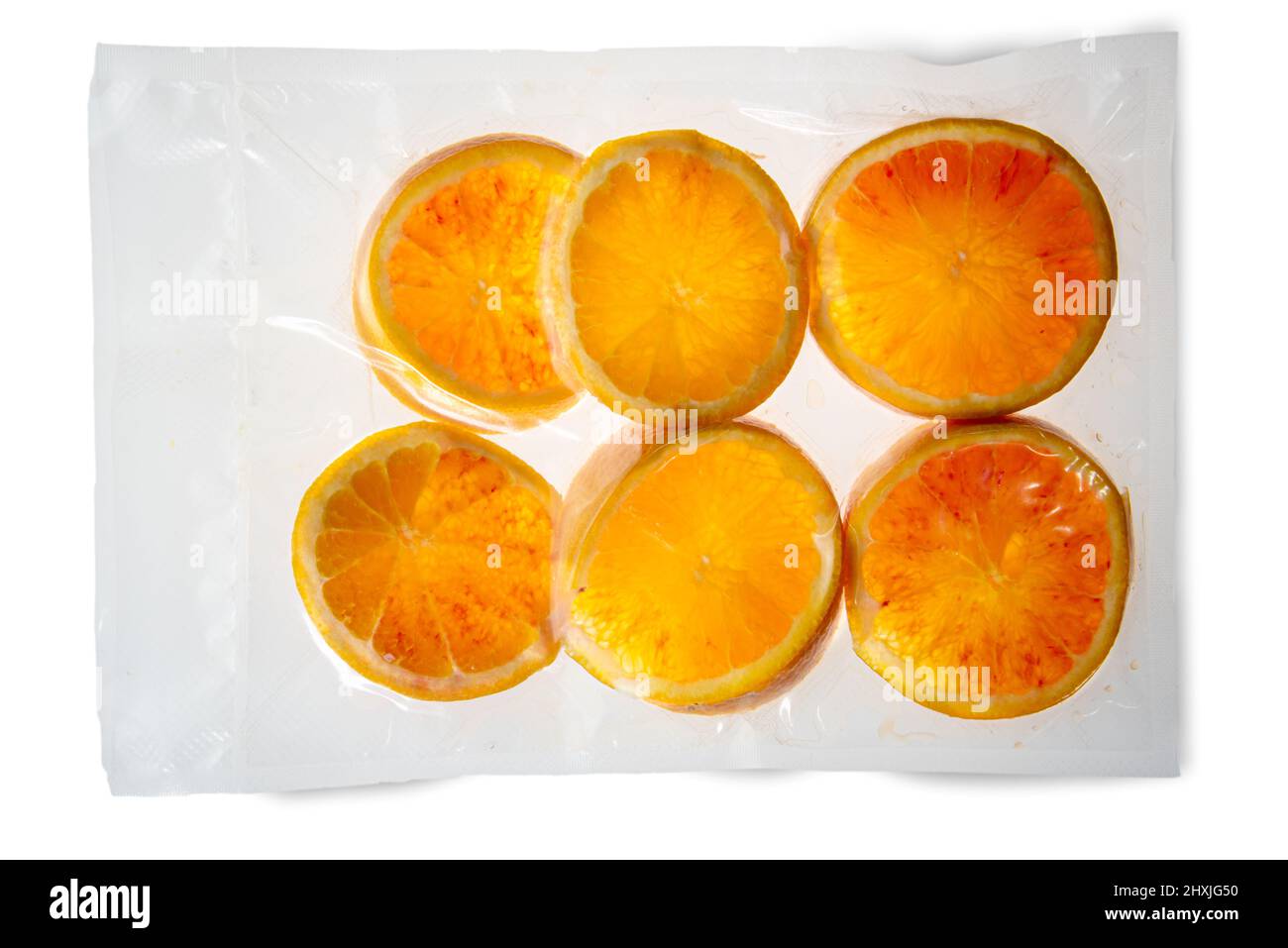 Fette di arance Früchte in vakuumverpackter, versiegelter Verpackung für Sous-Vide-Kochen isoliert auf weißem Hintergrund in der Draufsicht Stockfoto