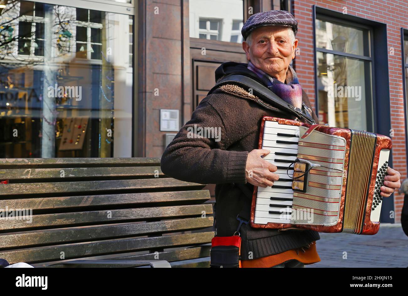 Düsseldorf, Deutschland - März 9. 2022: Nahaufnahme eines alten, stehenden Mannes mit Hut, der auf einer öffentlichen Straße Klavier spielt Stockfoto