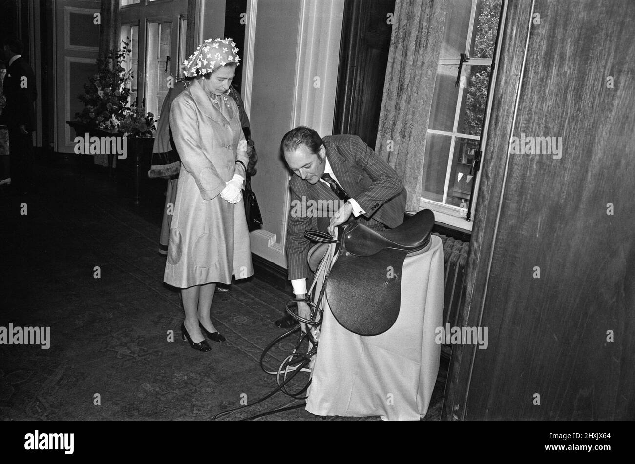 Königin Elizabeth II. Besucht Walsall während ihrer Silver Jubilee Tour. West Midlands. Ein Geschenk für eine Königin, die Reiten liebt, einen Sattel und Zaumzeug von Walsall Lederherstellern. 27.. Juli 1977. Stockfoto