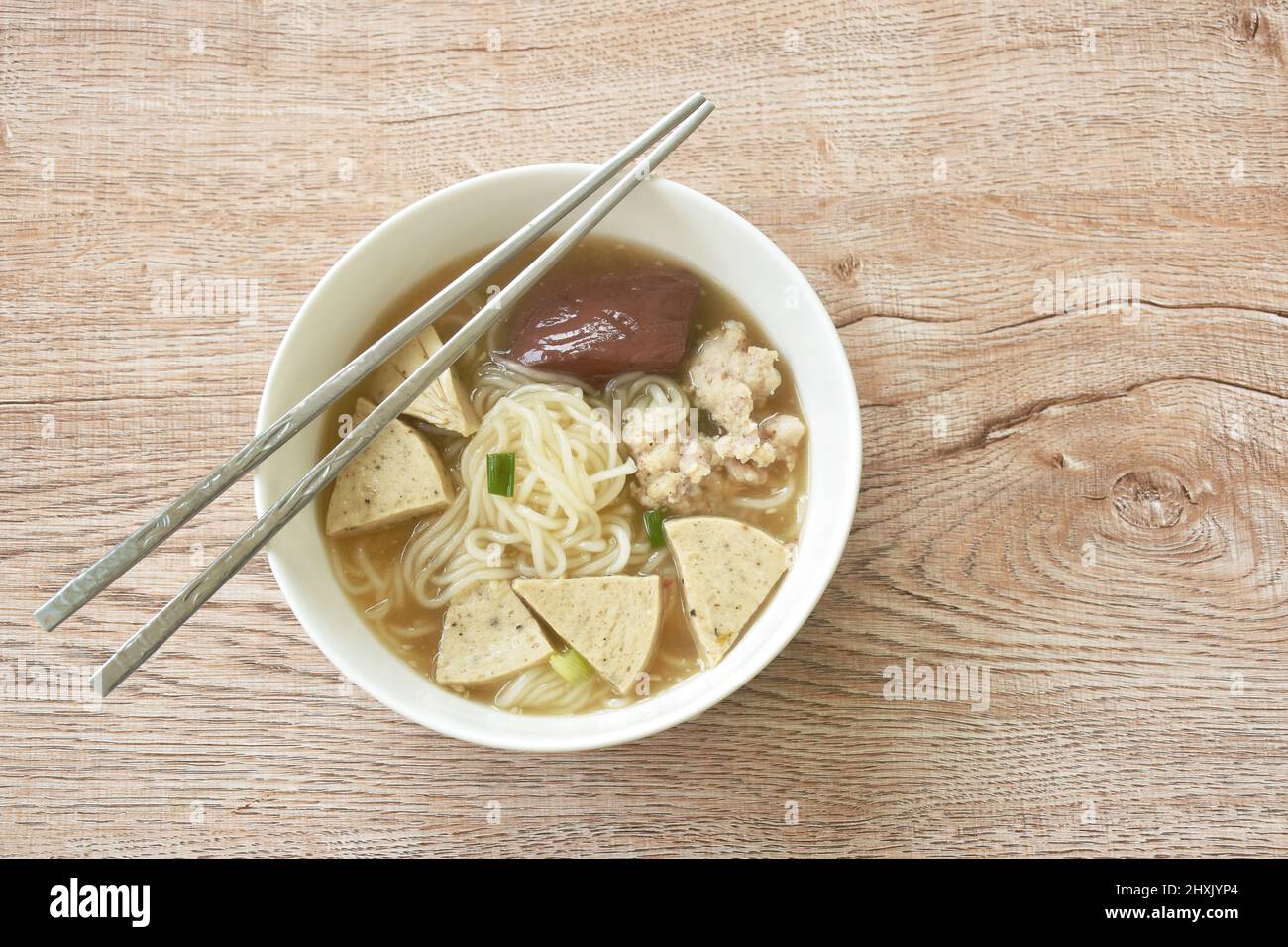 Vietnamesische Reisnudeln oder Pho mit Wurst in Scheiben schneiden und Schweinefleisch in einer Suppe auf einer Schüssel hacken Stockfoto