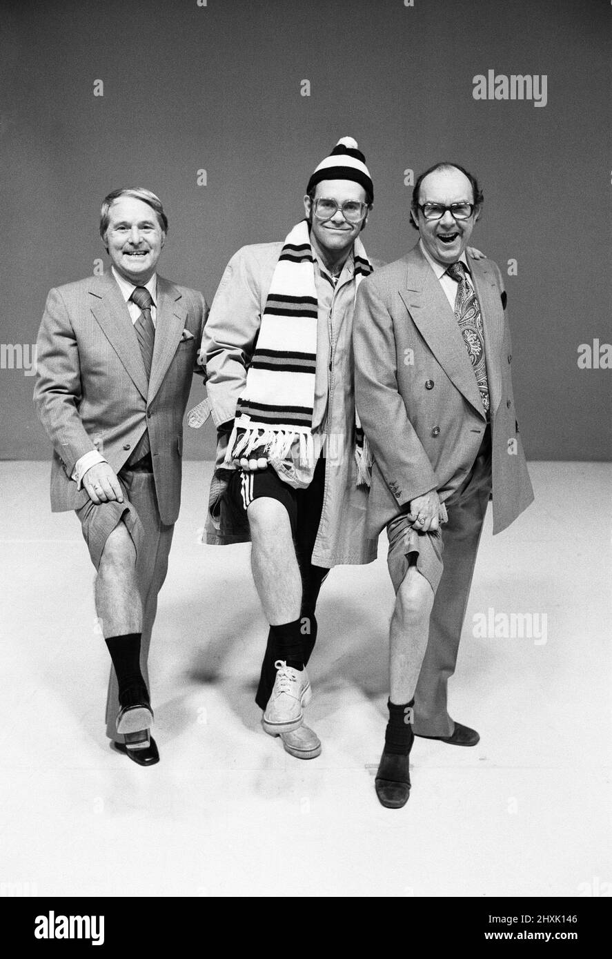 Elton John posiert mit den Komikern Ernie Wise (links) und Eric Morecambe, während er in der Morecambe- und Wise-Show im BBC-Fernsehzentrum auftritt.8.. Dezember 1976. Stockfoto