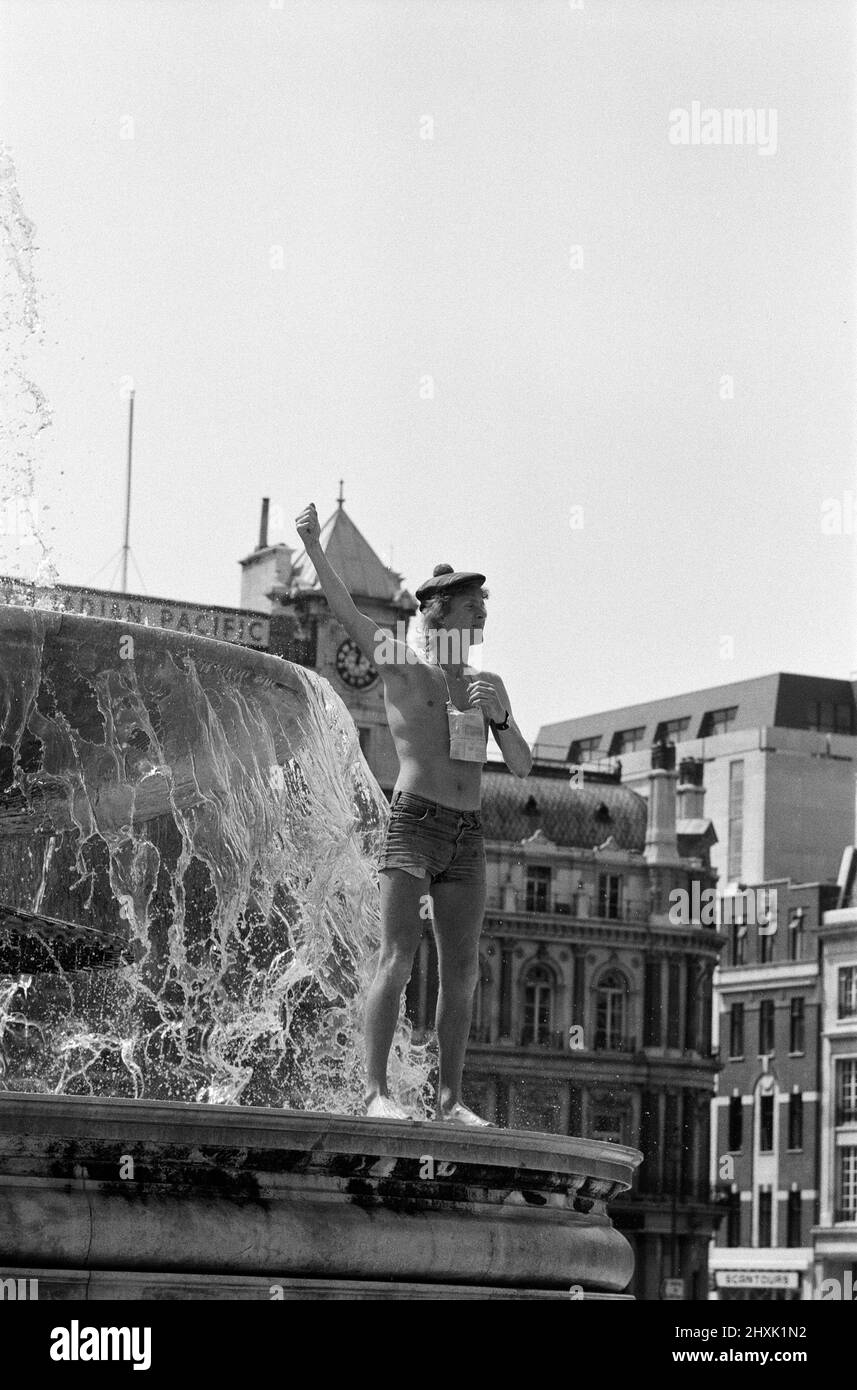 Hitzewelle am Trafalgar Square, London. Als die Temperaturen heute wieder in die 80s Grad aufstiegen, verlockten die kühlen Springbrunnen auf dem Trafalgar Square die Menschen, die um sie herum saßen, noch mehr und inspirierten das Gesetz, das besagt, dass es illegal ist, darin zu baden. 13.. Juni 1976. Stockfoto