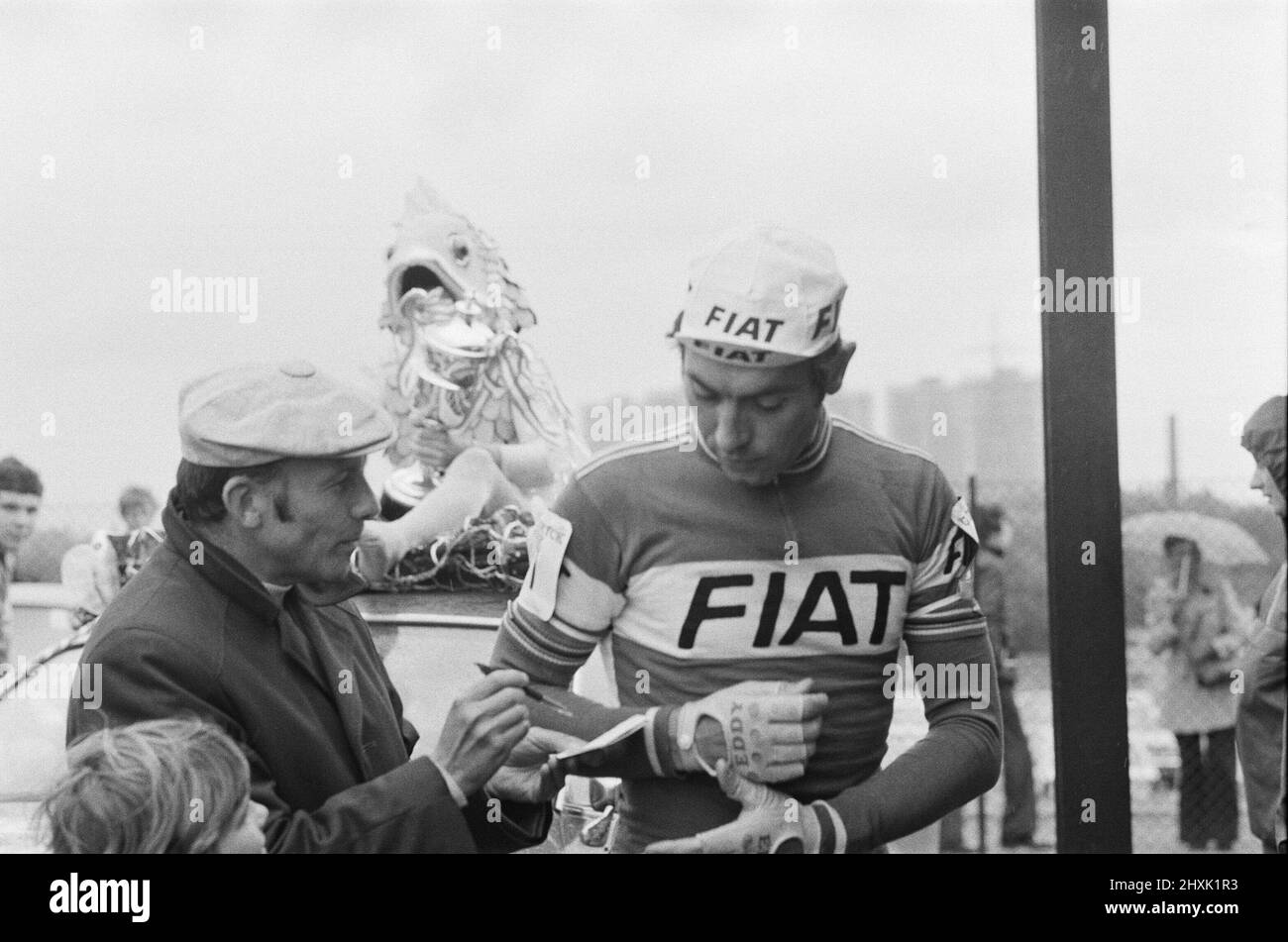 Eddy Merckx wird gebeten, sein Autogramm für einen Fan zu unterschreiben, da er am Samstag, den 11.. Juni, am größten Rennrad-Event des britischen Berufsstandes, dem Glenryck Cup 1977 auf dem Eastway Cycling Track, Lee Valley bei Stratford, London, teilnimmt. Sieger wurde der Westdeutsche Dietrich Thurau. 2. war die britische Sid Barras und Dritter war der Belgier Eddy Merckx. Eddy Merckx richtiger Name ist Édouard Louis Joseph, Baron Merckx Bild aufgenommen am 11.. Juni 1977 Stockfoto