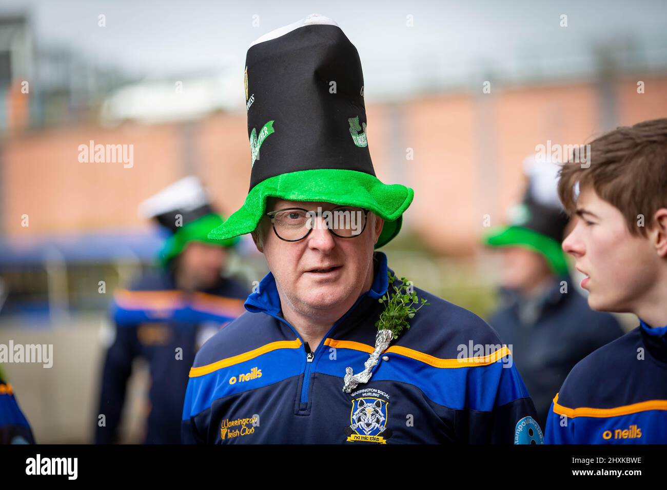 Warrington, Hes. 13. März 2022. Der Warrington Irish Club ist Gastgeber des Services und des Starts der St. Patrick's Day Parade. Dies ist die erste Parade seit dem Start von COVID. Beginnend um 10,30 Uhr morgens vom Irish Club in Orford Lane zum ‘River of Life' in der Bridge Street im Stadtzentrum, wo ein kurzer Gottesdienst abgehalten wurde, um an den Jahrestag des Bombenanschlags von Warrington zu erinnern. Es regnete, sobald die Parade begann und dann kam die Sonne heraus Credit: John Hopkins/Alamy Live News Stockfoto