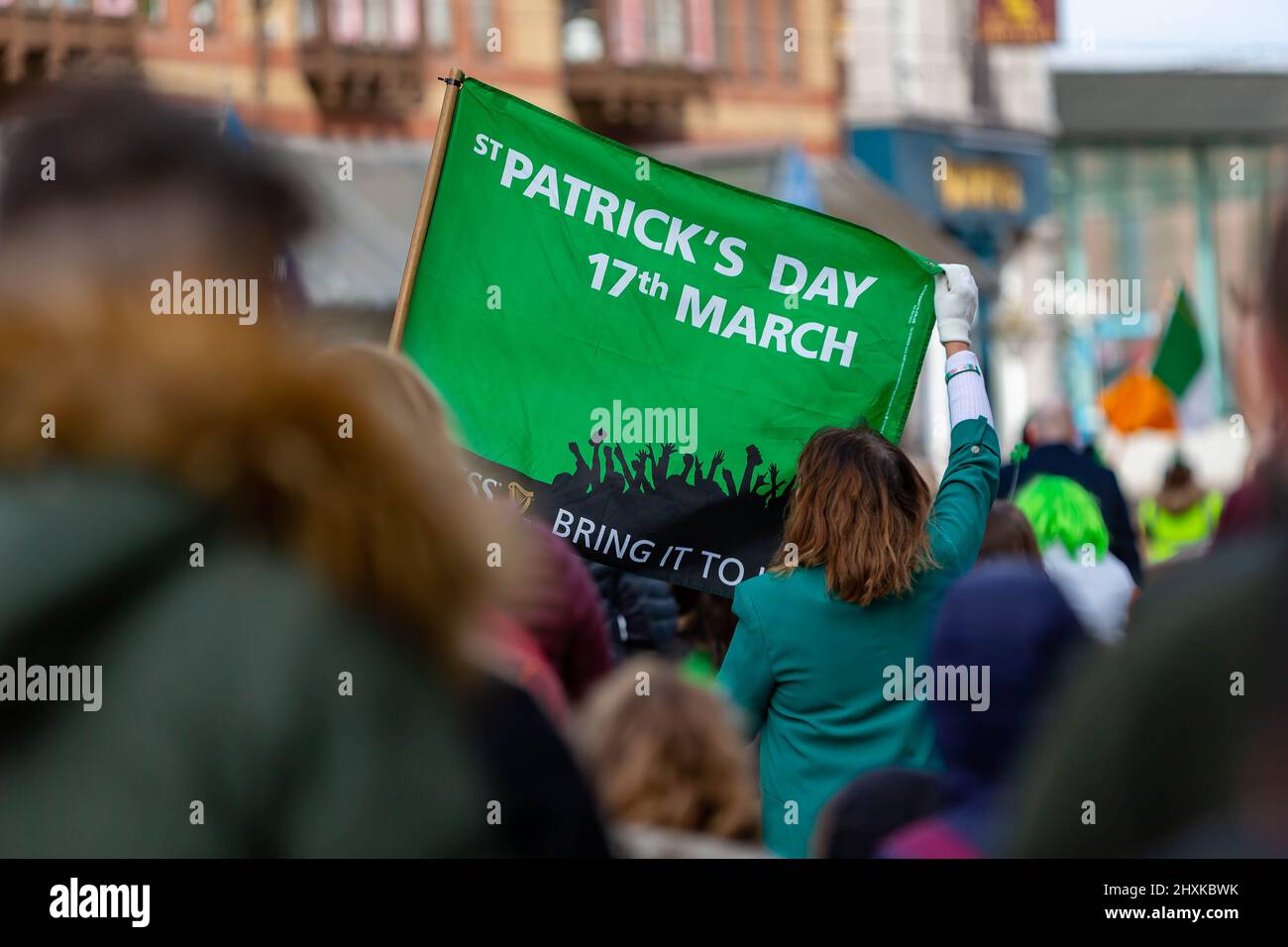 Warrington, Hes. 13. März 2022. Der Warrington Irish Club ist Gastgeber des Services und des Starts der St. Patrick's Day Parade. Dies ist die erste Parade seit dem Start von COVID. Beginnend um 10,30 Uhr morgens vom Irish Club in Orford Lane zum ‘River of Life' in der Bridge Street im Stadtzentrum, wo ein kurzer Gottesdienst abgehalten wurde, um an den Jahrestag des Bombenanschlags von Warrington zu erinnern. Es regnete, sobald die Parade begann und dann kam die Sonne heraus Credit: John Hopkins/Alamy Live News Stockfoto