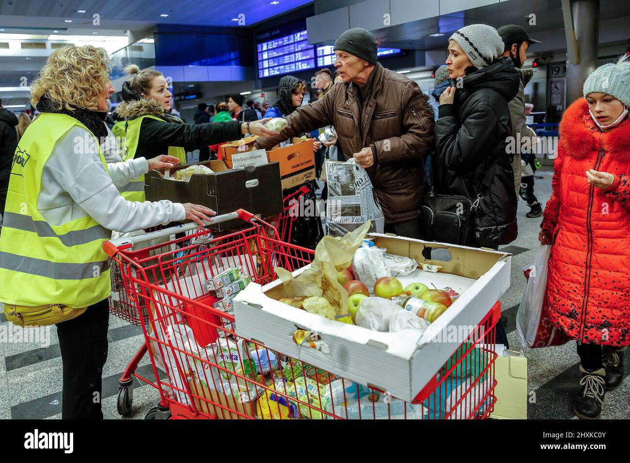 Polnische Frauen geben ukrainischen Flüchtlingen Nahrung, da viele Polen freiwillig Hilfe für kriegsgeplagte Flüchtlinge am Hauptbahnhof in Krakau leisten, da bereits mehr als 1,5 Millionen Menschen aus der Ukraine nach Polen geflohen sind. Während die Russische Föderation in die Ukraine einmarschierte, wird der Konflikt voraussichtlich bis zu 5 Millionen Ukrainer zur Flucht zwingen. Viele der Flüchtlinge werden in Polen Asyl beantragen. Die meisten karitativen Hilfen in Polen werden von Einzelpersonen, NGOs und Unternehmen geleistet. Die Flüchtlinge werden oft von Einzelpersonen und NGOs aufgenommen. Stockfoto