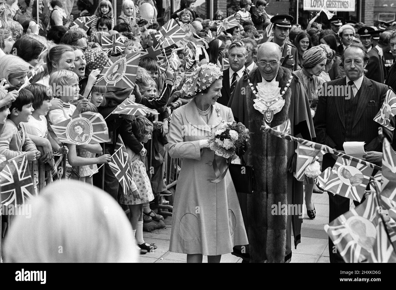 Königin Elizabeth II. Während ihres Besuchs in Solihull, den West Midlands, für ihre Silver Jubilee Tour. Die Königin auf einem Spaziergang auf dem Mell Square, Solihull. Hinter ihr steht der Bürgermeister der Stadt, Stadtrat Norman Green. 27.. Juli 1977. Stockfoto