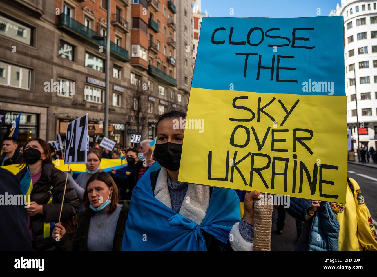 Madrid, Spanien. 13. März 2022. Demonstranten, die Plakate und ukrainische Flaggen tragen, werden während einer Demonstration gegen die russische Invasion in die Ukraine gesehen. In Madrid lebende Ukrainer und spanische Anhänger marschierten durch die Stadt und forderten das Ende des Krieges in der Ukraine, protestierten gegen den russischen Präsidenten Wladimir Putin und forderten von der NATO, den Himmel über der Ukraine zu schließen. Quelle: Marcos del Mazo/Alamy Live News Stockfoto