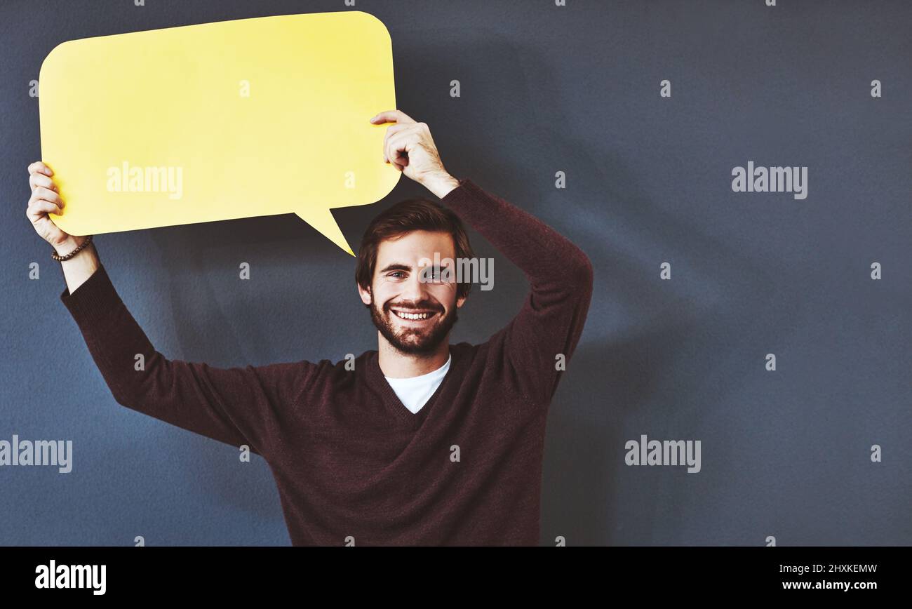 Sie wissen genau, was sie denken. Studioporträt eines jungen Mannes, der eine Sprechblase vor einem grauen Hintergrund hält. Stockfoto