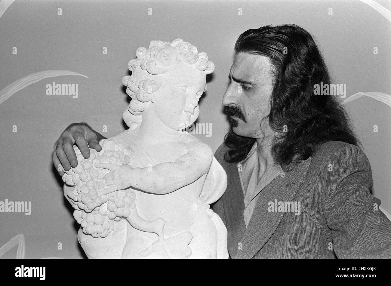 Frank Zappa. Amerikanischer Musiker.im Dorchester Hotel in London. Die Cherub-Statue gehört zum Hotel. Bild aufgenommen am 8h. Februar 1977 Stockfoto