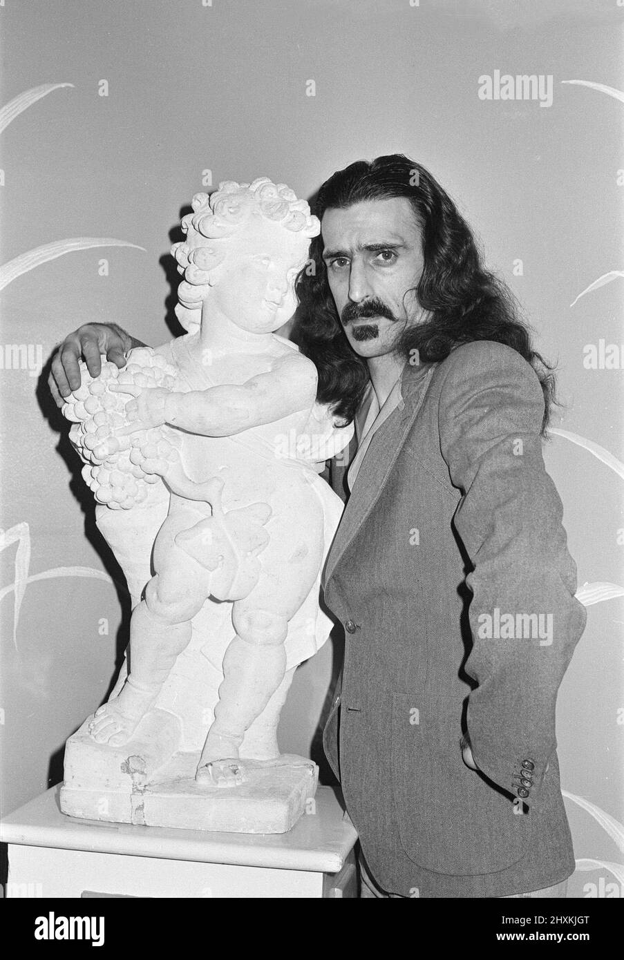 Frank Zappa. Amerikanischer Musiker.im Dorchester Hotel in London. Die Cherub-Statue gehört zum Hotel. Bild aufgenommen am 8h. Februar 1977 Stockfoto