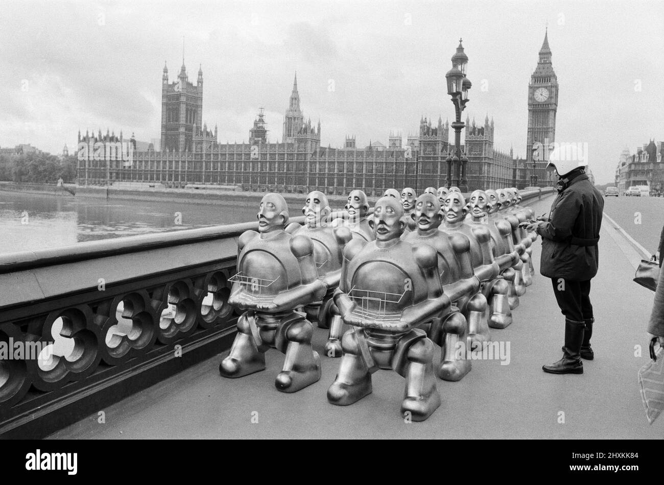 Roboter standen über der Westminster Bridge. Die Roboter wurden von EMI Records geliefert, die sie auf dem Cover des neuesten Albums von 'Queen' verwendeten. Nachdem die Invasion von Westminster von einem einzigen Verkehrspolizisten gestoppt wurde, hatte ein einzelliger Roboter einen kurzen Blick auf den Buckingham Palace, das Haus der anderen Königin. 2.. November 1977. Stockfoto