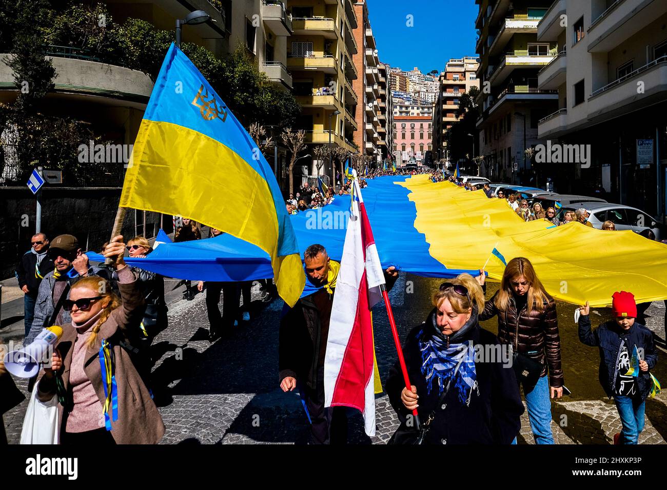 Die ukrainische Gemeinschaft in neapel ist heute, am 13. märz 2022, mit einer Demonstration entlang der Straßen von neapel bei der Ankunft am amerikanischen Konsulat, die eine große ukrainische Flagge mit einer Länge von etwa fünfzig Metern zeigt und fordert, dass die nato den Luftraum in der ukraine schließt, um die Bombardierung von Städten durch russland zu verhindern. Stockfoto