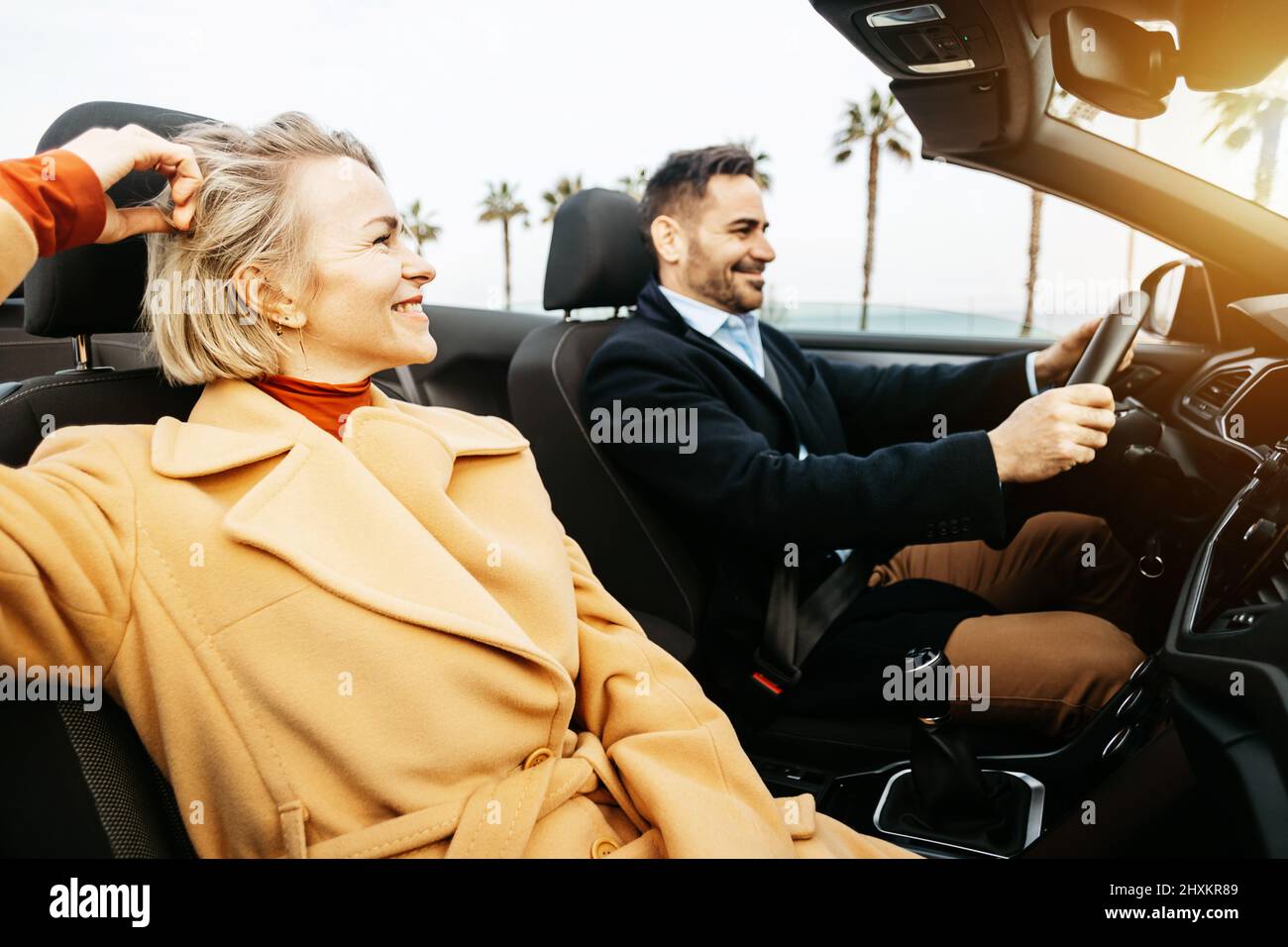 Mittelerwachsenes Paar, das im Urlaub Spaß mit dem Cabrio hat Stockfoto
