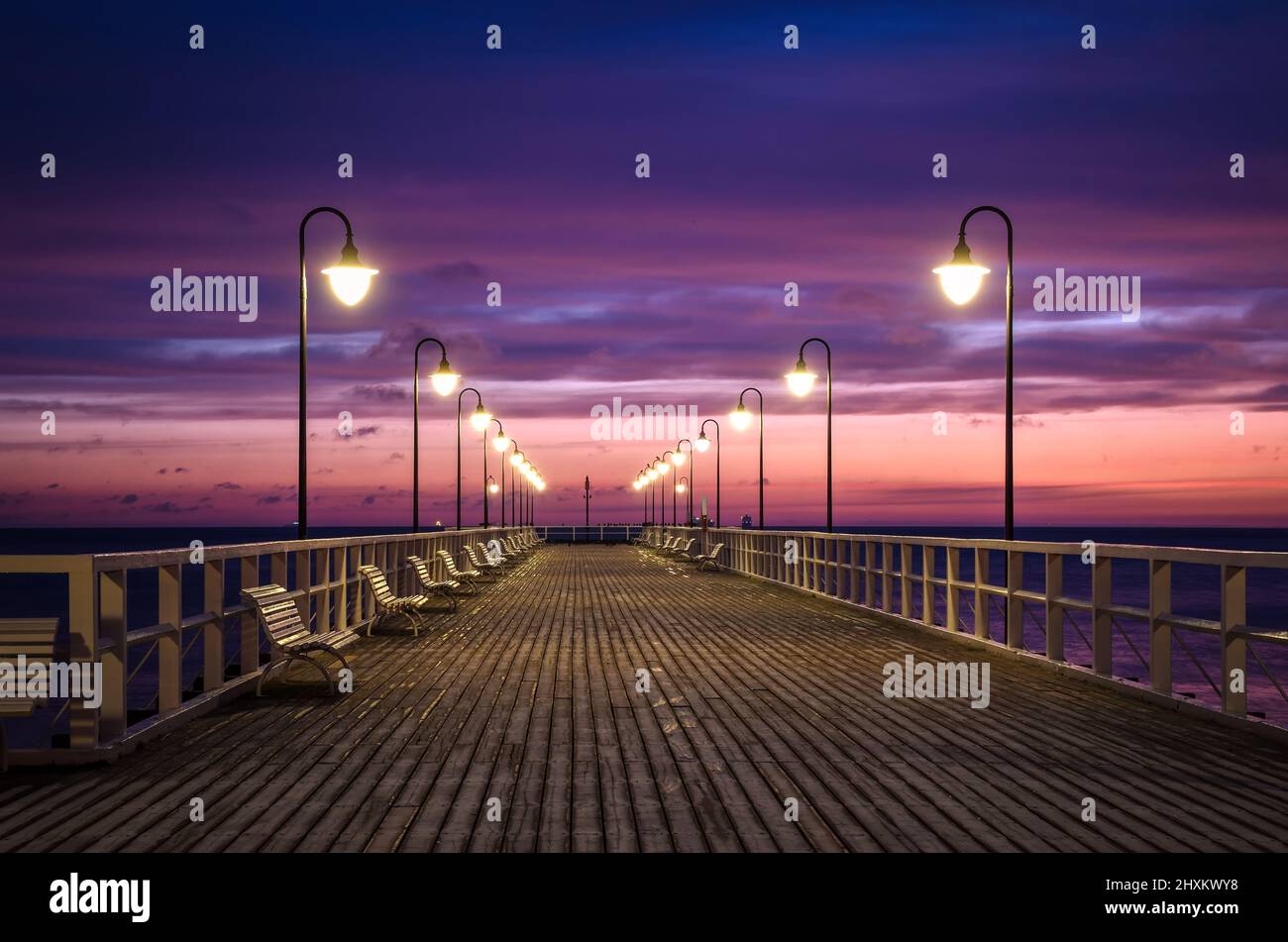 Wunderschöne Landschaft am Morgen am Meer. Hölzerner Pier mit einem bunten Himmel in Gdynia Orlowo, Polen. Stockfoto
