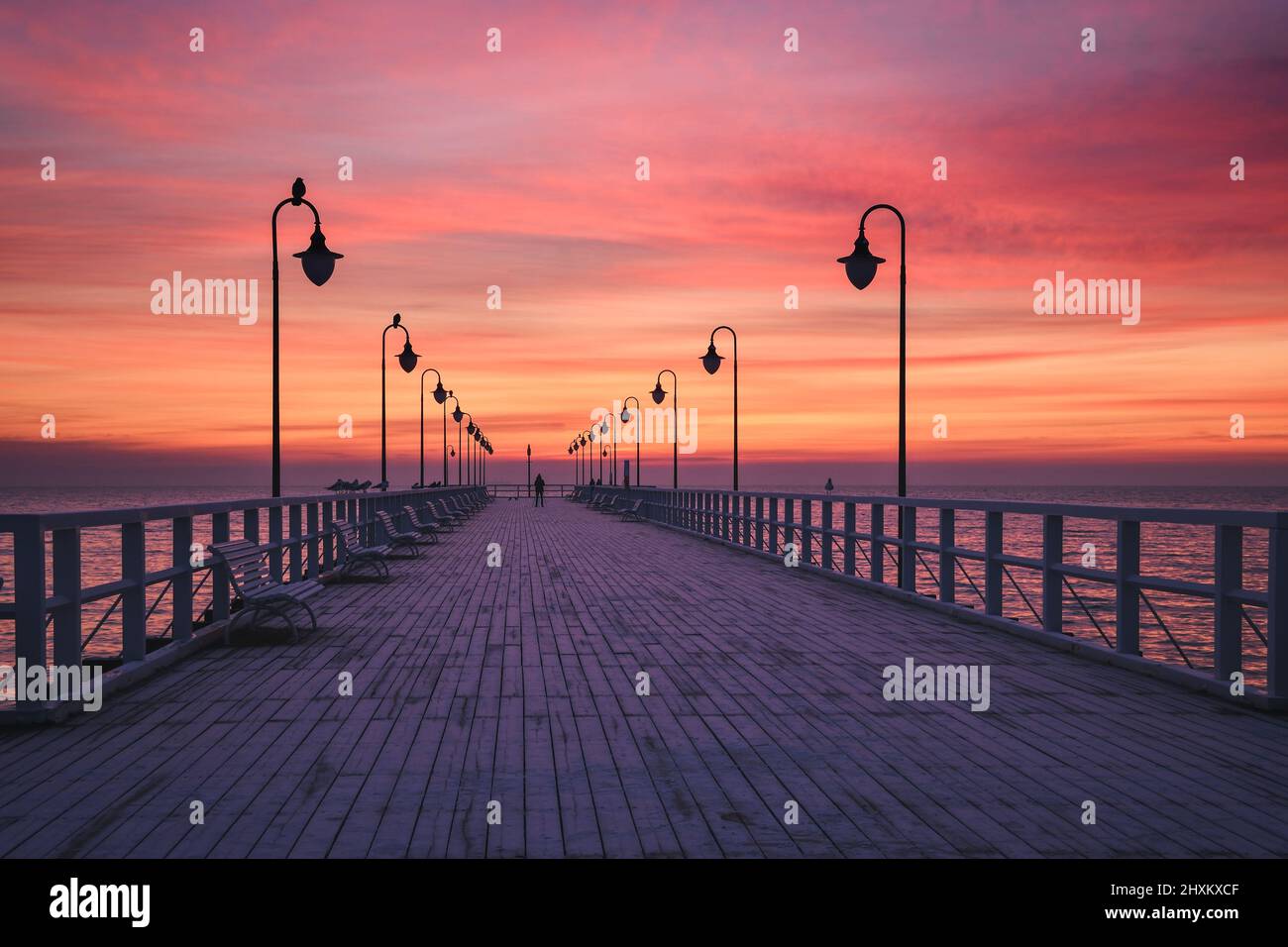 Wunderschöne Landschaft am Morgen am Meer. Hölzerner Pier mit einem bunten Himmel in Gdynia Orlowo, Polen. Stockfoto