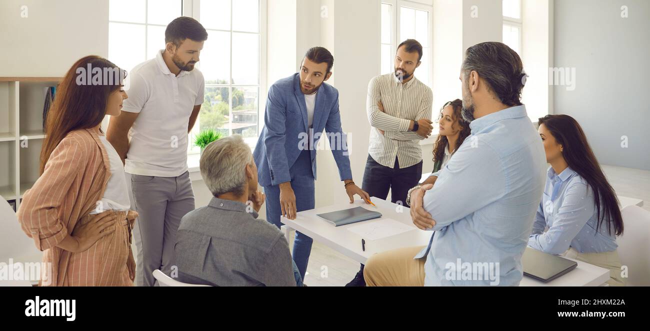 Das Business-Team hört während der Arbeitssitzung im Büro seinem Vorgesetzten zu Stockfoto