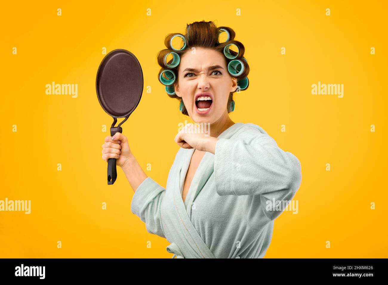 Wütend Frau Schreiend Halten Frying Pan Über Gelb Studio Hintergrund Stockfoto