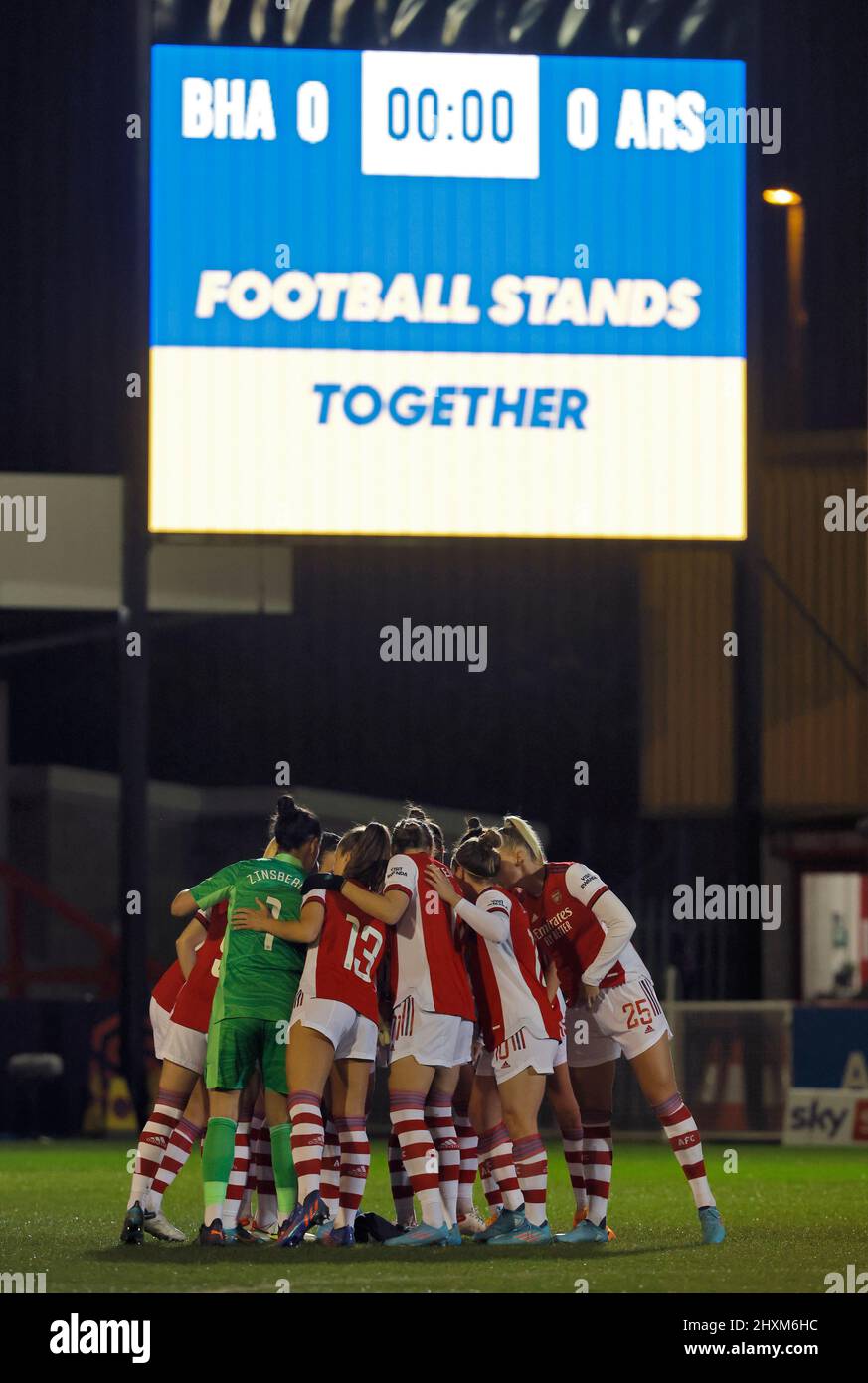 Arsenal-Spieler in einer Gruppe spielen zusammen, während „Football steht zusammen“ auf der Großleinwand vor dem Barclays FA Women's Super League-Spiel im People's Pension Stadium, Crawley, angezeigt wird. Bilddatum: Sonntag, 13. März 2022. Stockfoto