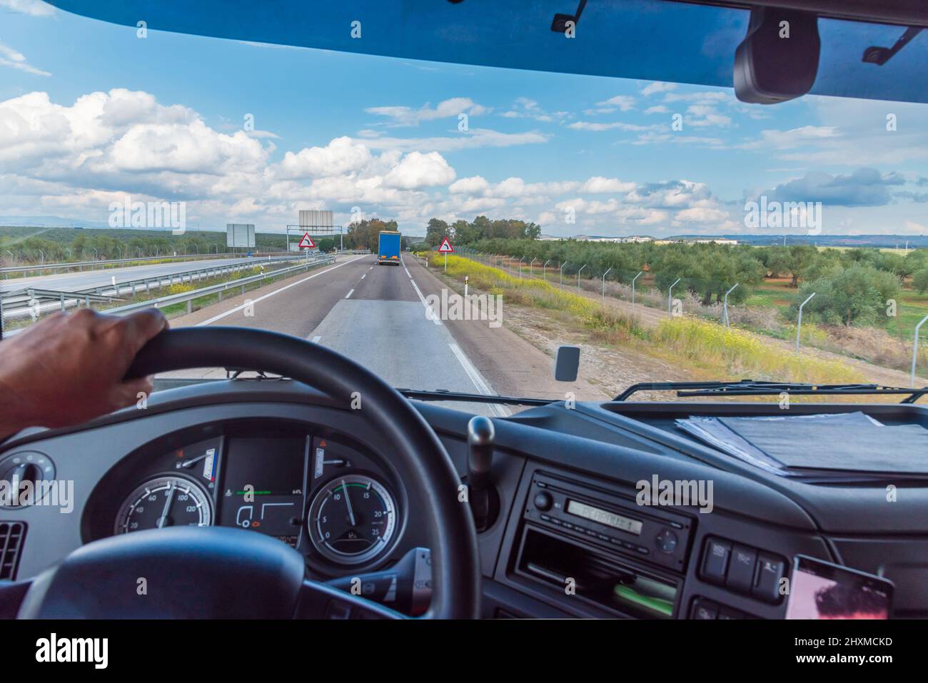 Blick auf die Straße aus der Fahrposition eines LKW einer Landschaft mit Wolken. Stockfoto