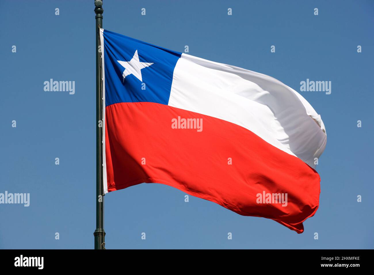 CHILENISCHE FLAGGE AUF FAHNENMAST IN KLAREM BLAUEN HIMMEL Stockfoto