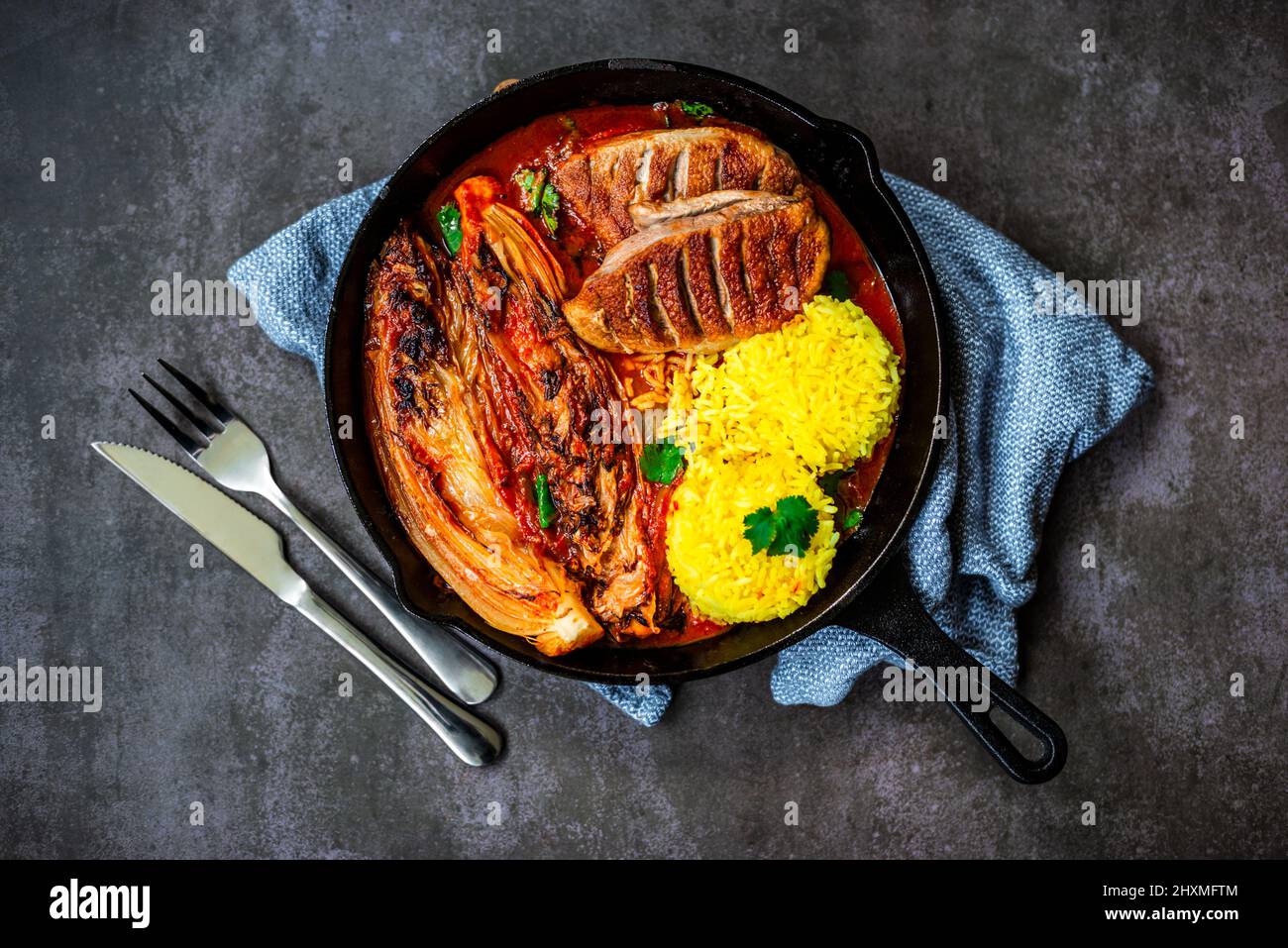 Gegrillte Ente mit napa-Kohl und Safranreis in gusseiserner Pfanne Stockfoto