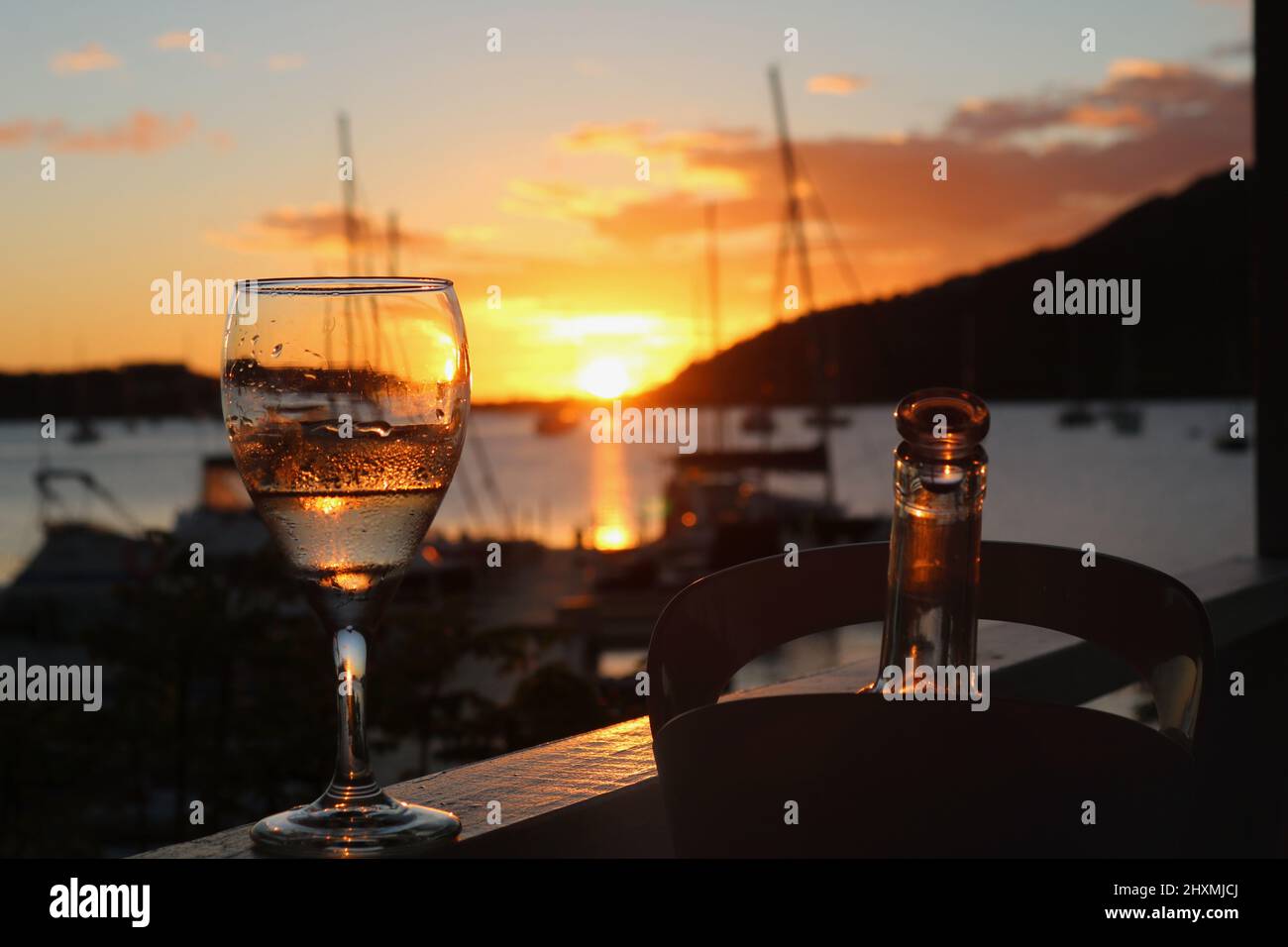 Sonnenuntergang durch eine Weinglass gesehen und Yachten im englischen Hafen, Britische Jungferninseln, betrachtet Stockfoto