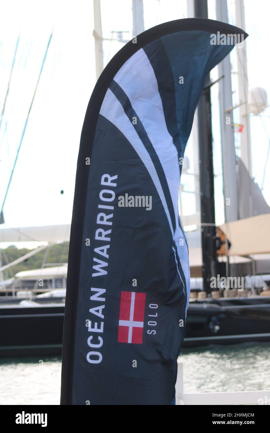 Flagge mit der Aufschrift "Ocean Warrior" mit dänischer Flagge und Yachten im Hintergrund Stockfoto