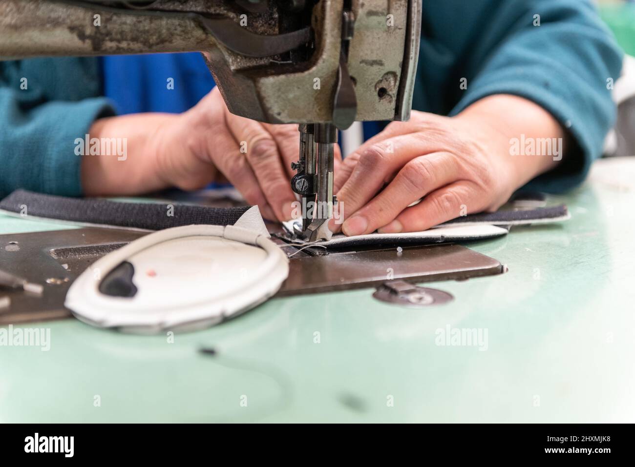 Ledermuster werden von erfahrenen Händen zusammengenäht, um das Produkt in größeren Mengen herzustellen. Stockfoto