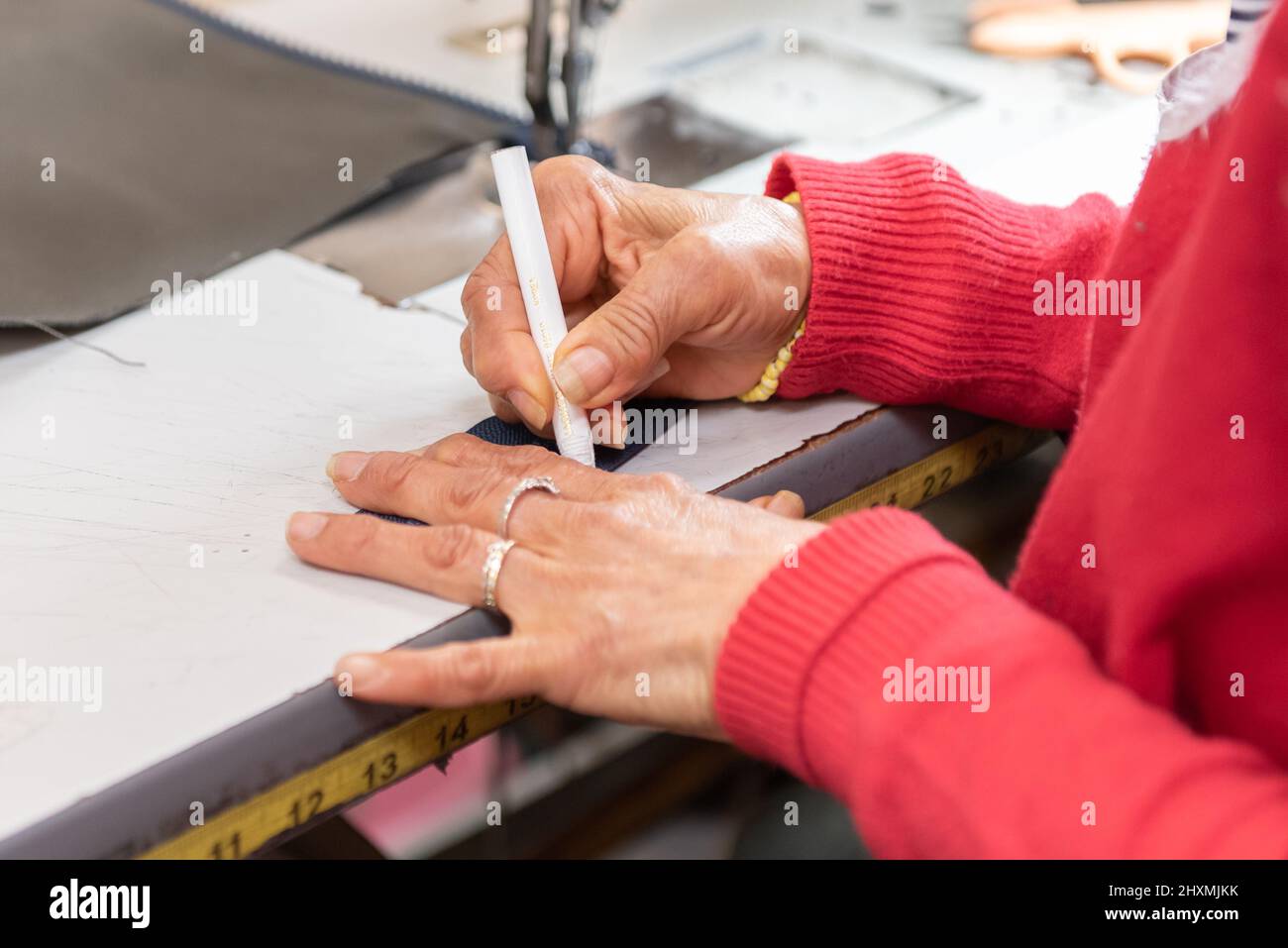 Erfahrene Hände, die präzise Markierungen auf dem Leder für die beste Qualität in der Produktion machen. Stockfoto