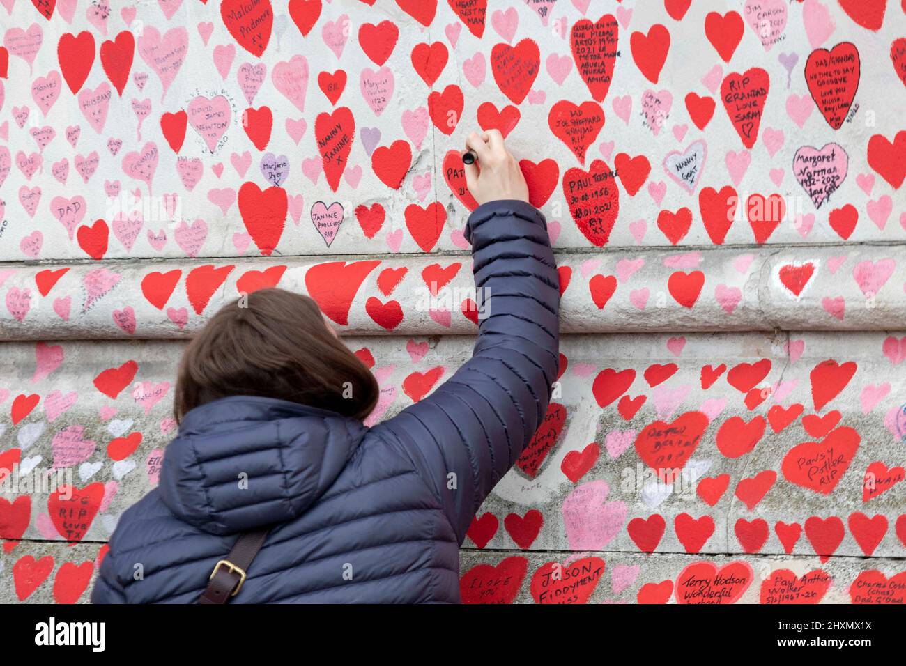 Die Menschen geben ihre Widmungen auf neu bemalten Herzen an der COVID-Wand ab. Am 29.. März 2022 jährt sich zum ersten Mal das Herz dra Stockfoto