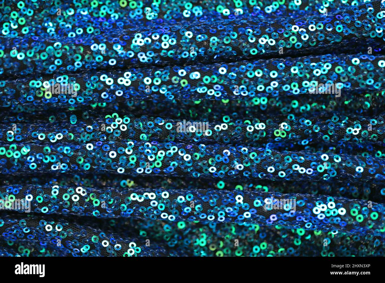Pailletten Hintergrund.Stoff mit schimmernden Pailletten.Grün und blau Pailletten Hintergrund.glänzende Oberfläche in blauen und grünen Tönen. Schillernde Pailletten Textur. Stockfoto
