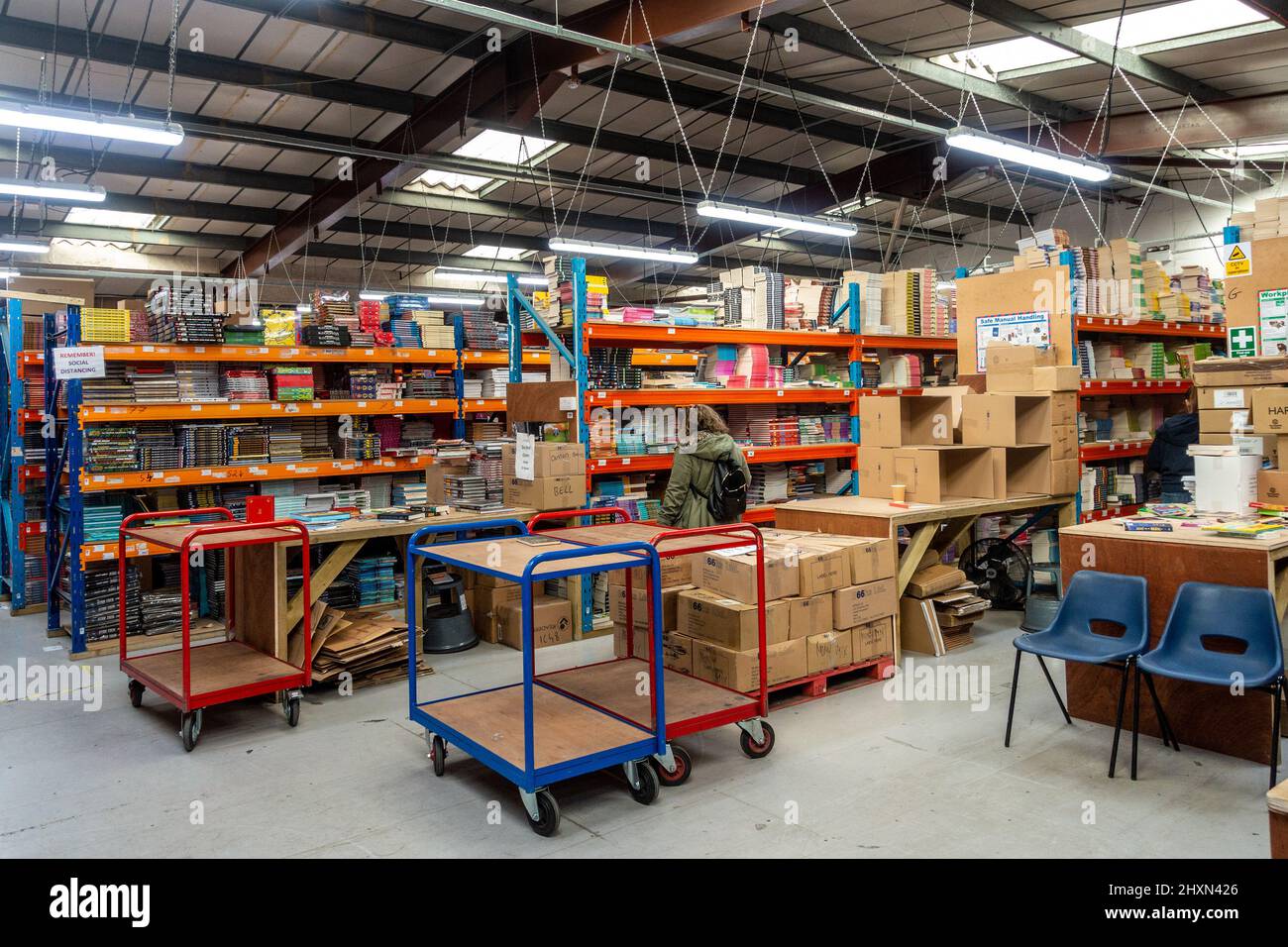 In einem Großhandelslager mit Bücherregalen, in denen sich Bücher stapeln. Stockfoto