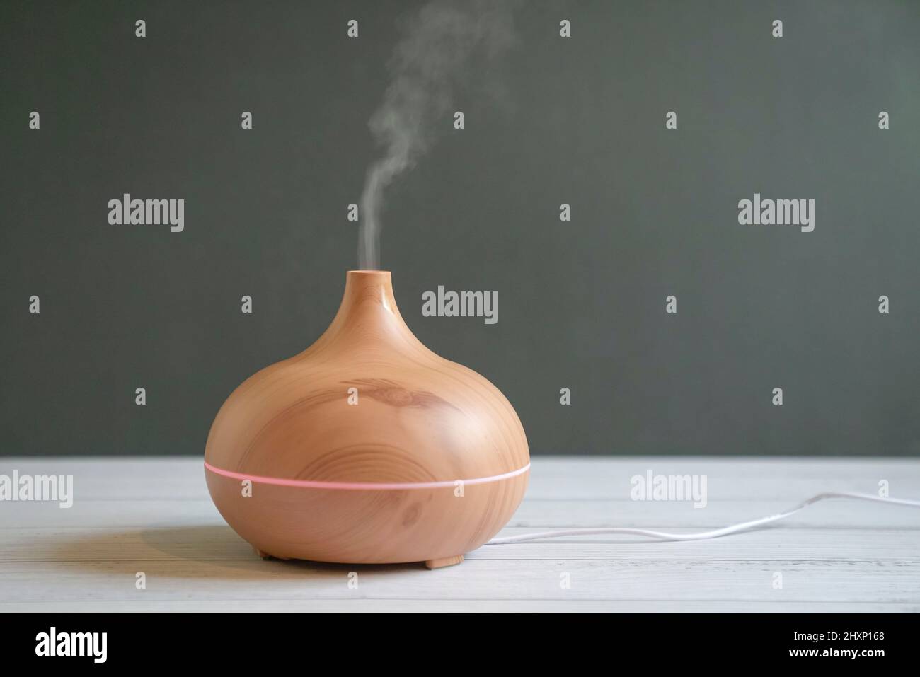 Aroma ätherisches Öl Diffusor auf dem Tisch. Grauer Hintergrund, Kopierbereich. Stockfoto