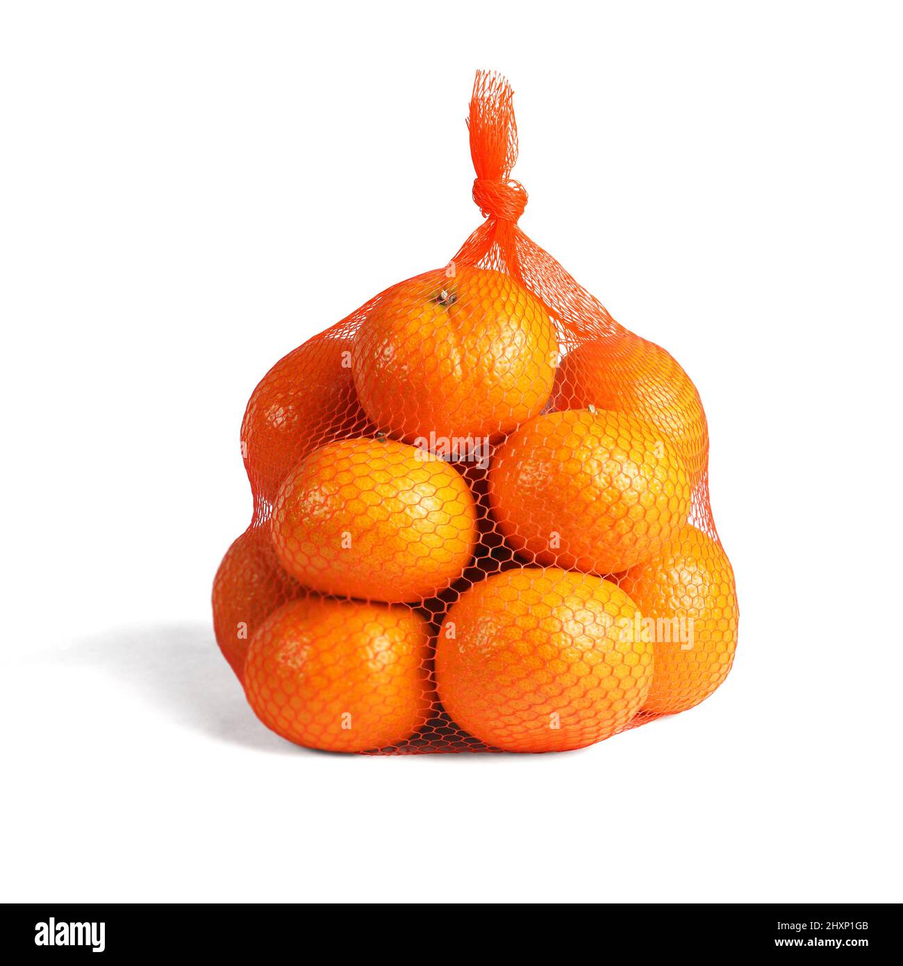 Mandarin Orangen in Plastikmaschensack auf weißem Hintergrund Stockfoto