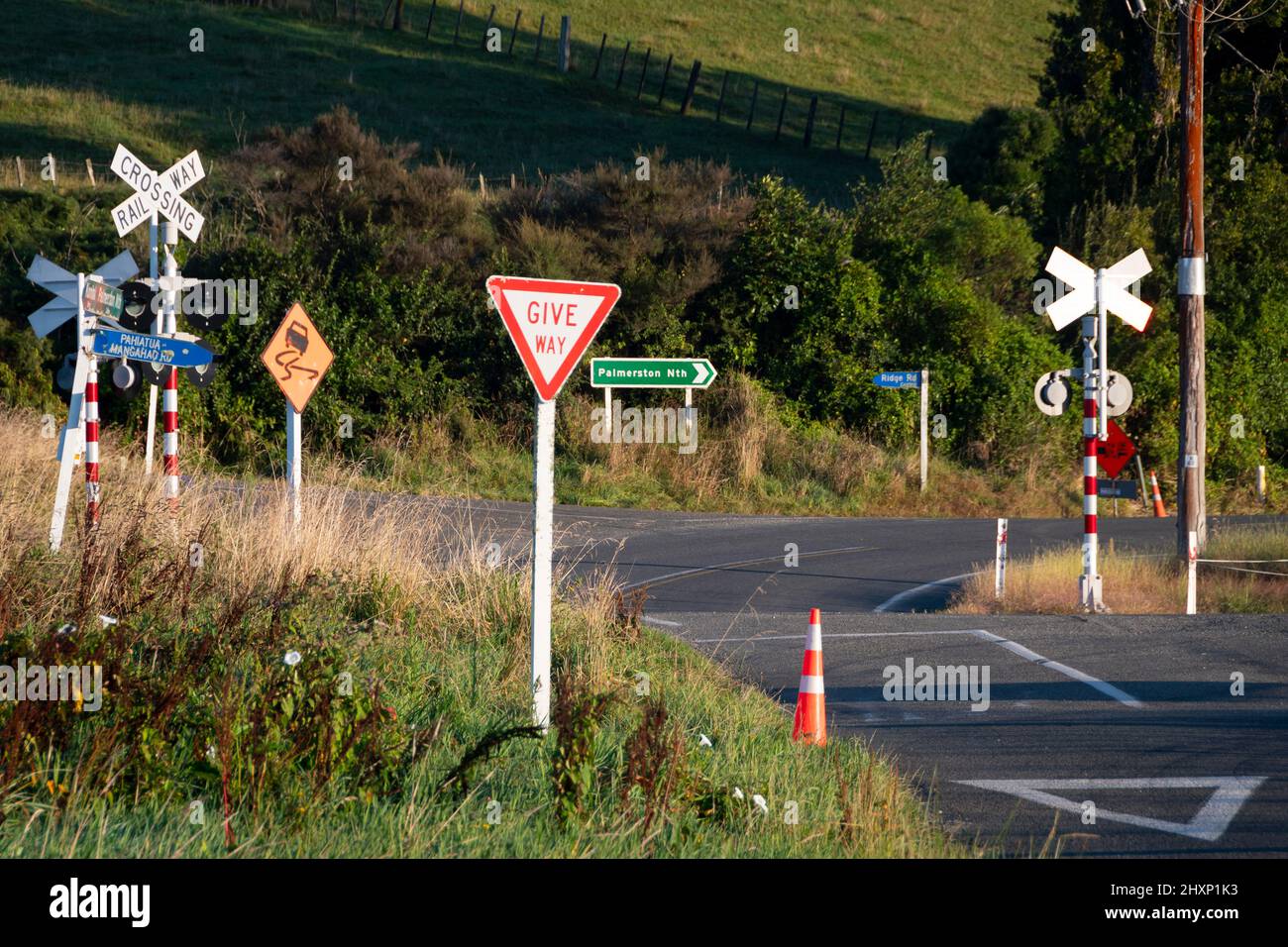 Straßenschilder an Kreuzung und Bahnübergang in der Nähe von Pahiatua, Tararua District, North Island, Neuseeland Stockfoto