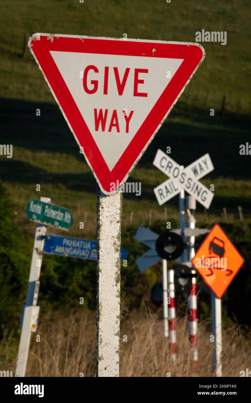 Straßenschilder an Kreuzung und Bahnübergang in der Nähe von Pahiatua, Tararua District, North Island, Neuseeland Stockfoto