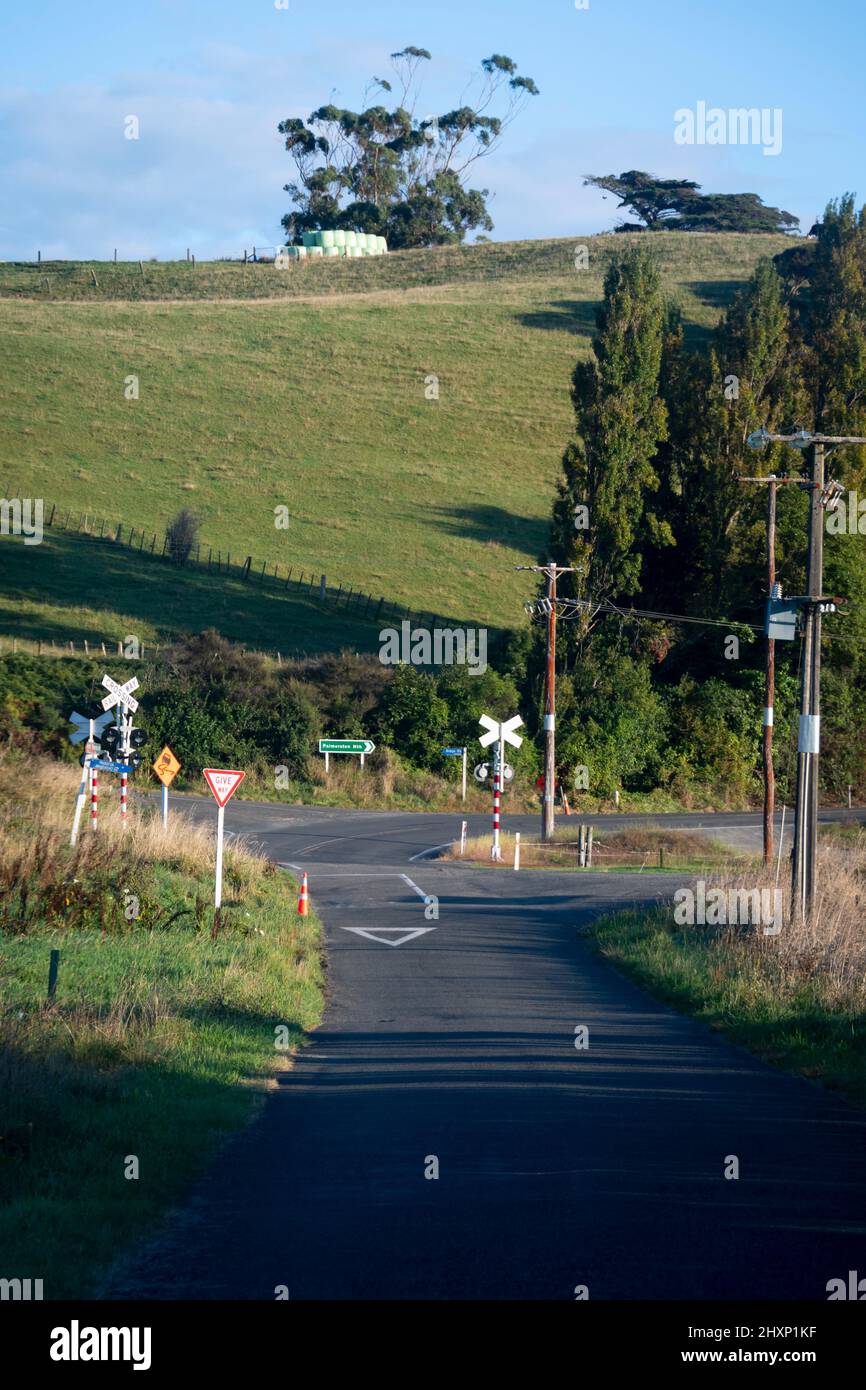 Straßenschilder an Kreuzung und Bahnübergang in der Nähe von Pahiatua, Tararua District, North Island, Neuseeland Stockfoto