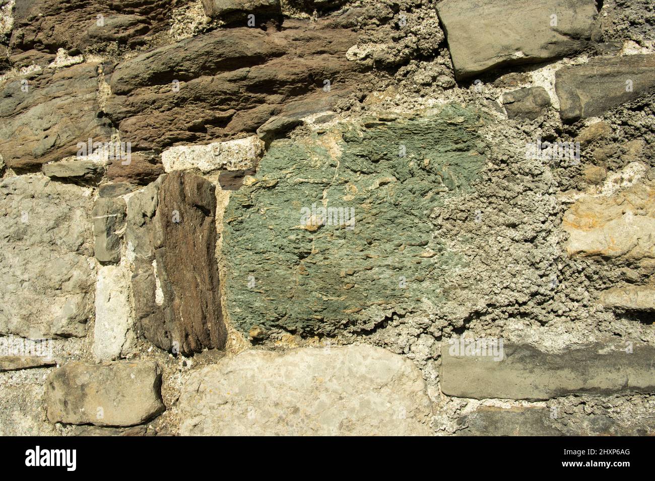 In die Außenwand des Beaumaris Castle auf der Isle of Anglesey wurden grob gehauene Blöcke aus lokalem metamorphem Gestein, einschließlich Schiefer, eingebaut Stockfoto