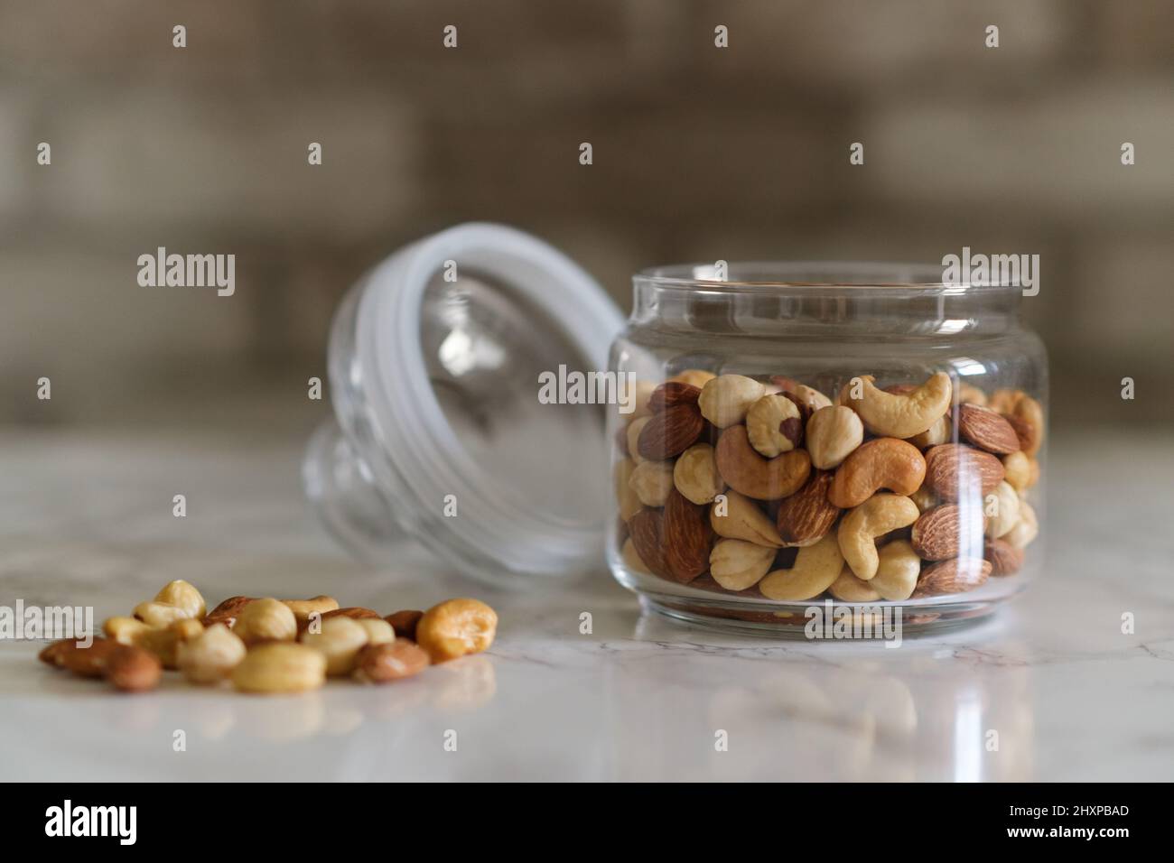 Mischen Sie Nüsse in einem transparenten Behälter, Cashewkerne, Mandeln, Haselnüsse Stockfoto