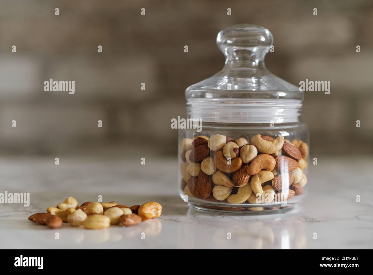 Mischen Sie Nüsse in einem transparenten Behälter, Cashewkerne, Mandeln, Haselnüsse Stockfoto