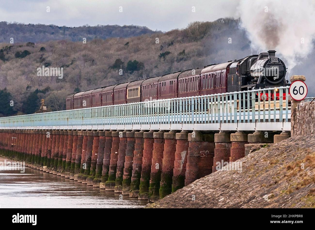 Restaurierte Dampfmaschine Leander, die mit dem Cumbrian Coast Express das Arnside Viadukt über den Fluss Kent überquert. Stockfoto