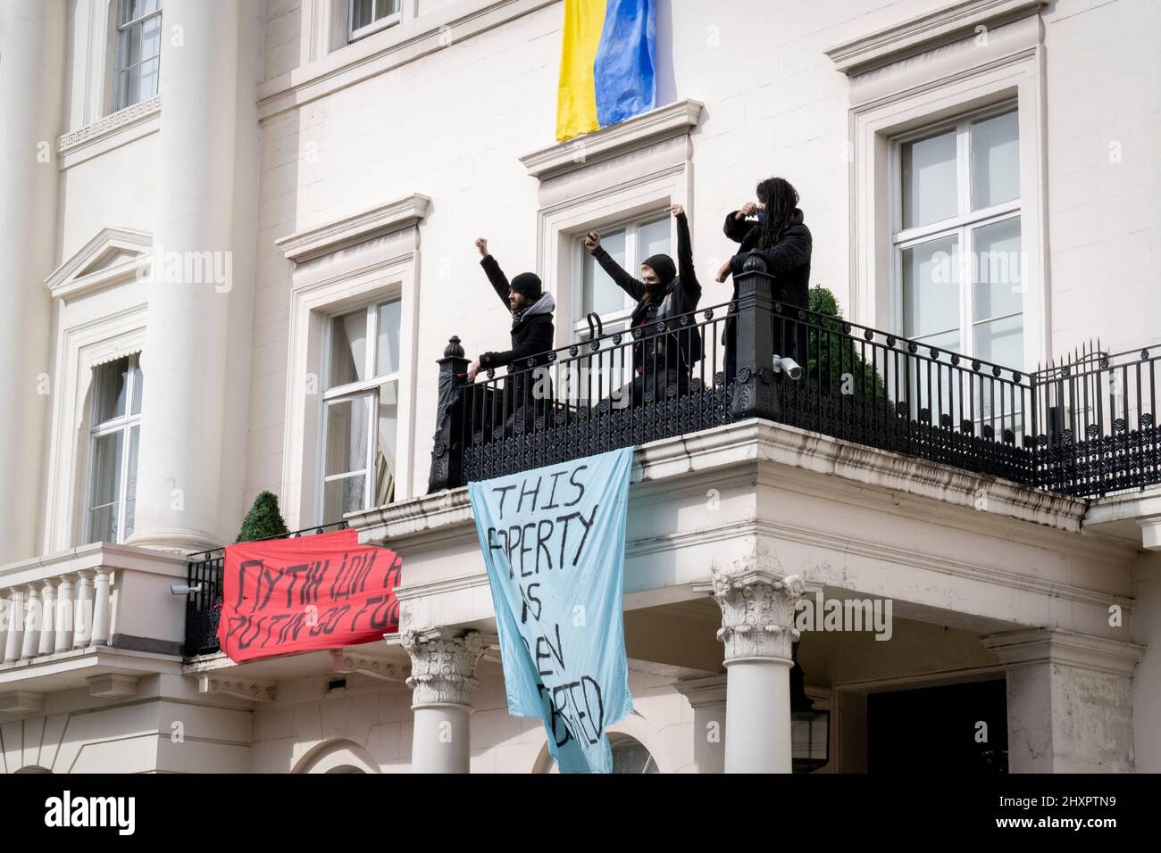 Demonstranten besetzen am 14.. März 2022 in London, England, das Eigentum des russischen Oligarchen und Putins Verbündeten Oleg Deripaska auf dem 5 Belgrave Square in Knightsbridge. Die Hausbesetzer haben die ukrainische Flagge an einem oberen Fenster gehängt und zeigen Banner mit den Aufschriften „Dieses Eigentum wurde befreit“ und einen Anti-Putin-Slogan. Stockfoto