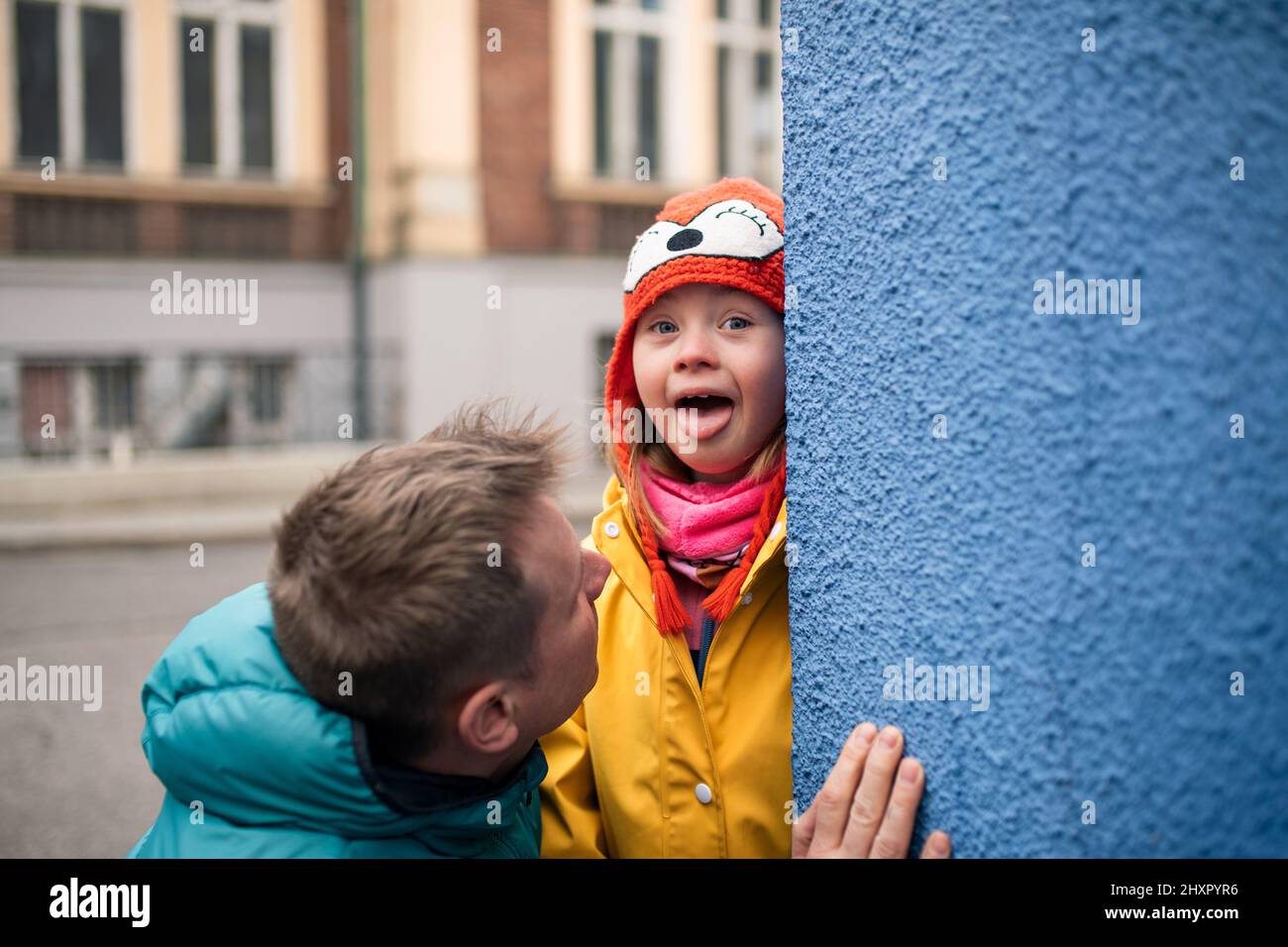 Vater mit seiner kleinen Tochter mit Down-Syndrom im Winter draußen auf der Straße Stockfoto
