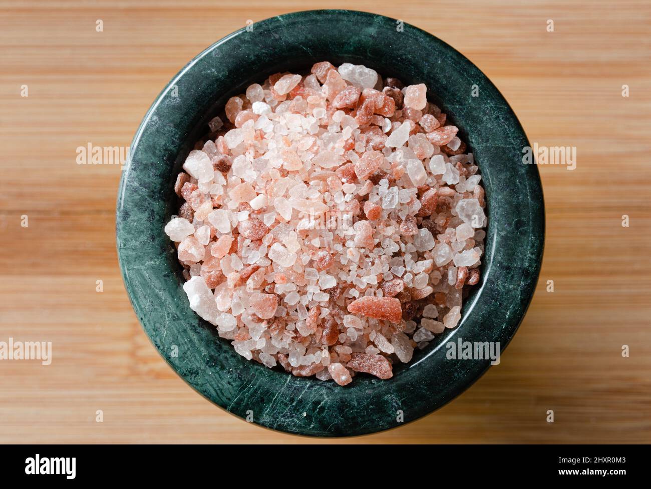 Draufsicht auf rosa Salz in grüner Schale auf Holztisch Stockfoto
