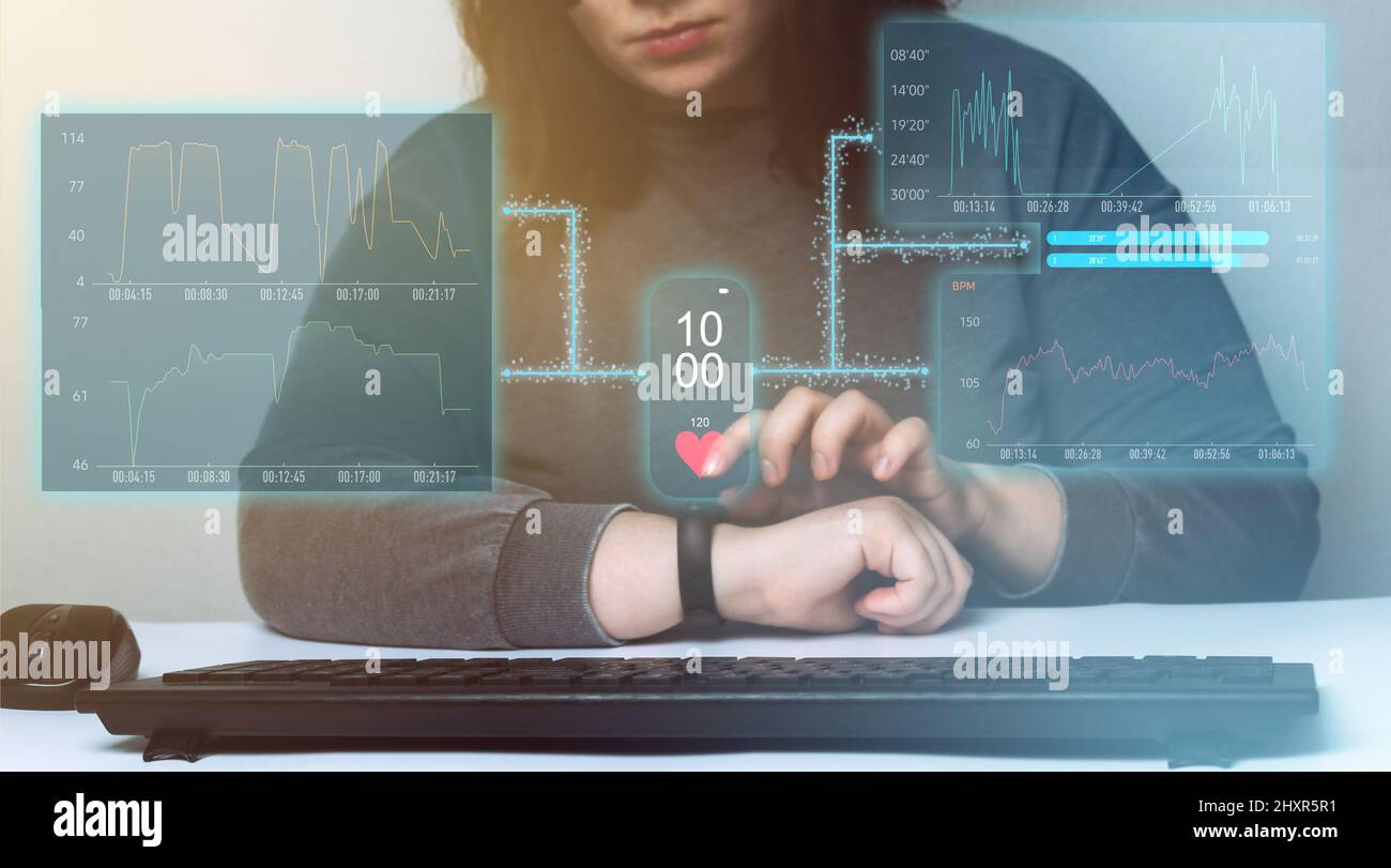 Frau, die auf ihrer Smartwatch mit Hologramm-Bildschirm-Schnittstelle ihre tägliche Aktivität überprüft. Futuristisches Übungskonzept. Stockfoto