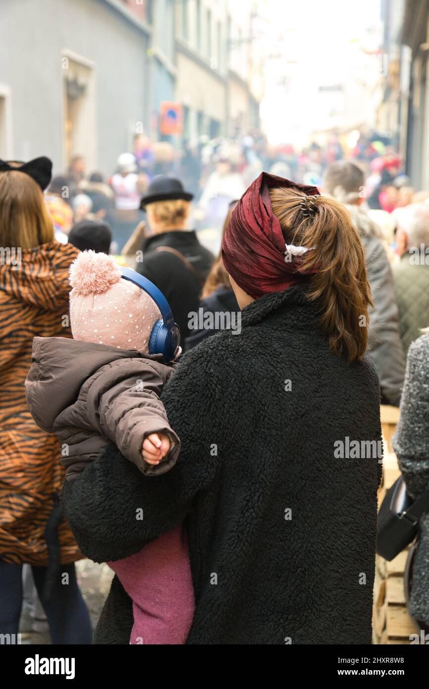 Vertikale Aufnahme einer Mutter mit ihrem Baby bei der Karnevalsparade in Luzern Stockfoto